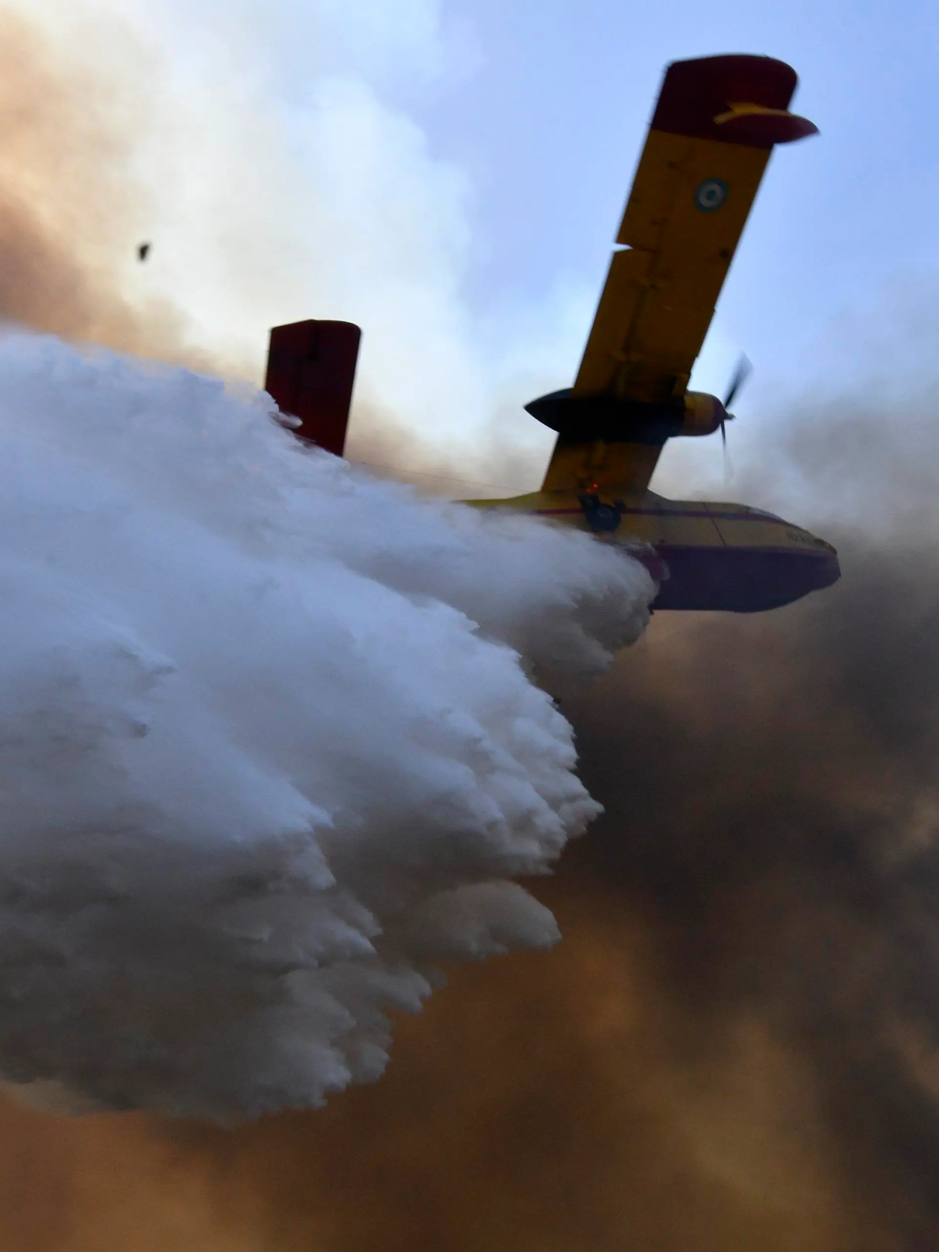 dpatopbilder - 05.08.2021, Griechenland, Olympia: Ein Flugzeug wirft Löschwasser über einem Waldbrand ab. Einsatzkräfte sind nach wie vor im Einsatz und bekämpfen Waldbrände. Das Feuer nördlich von Athen ist erneut voll aufgeflammt. Foto: Giannis Spyrounis/ilialive.gr/AP/dpa +++ dpa-Bildfunk +++