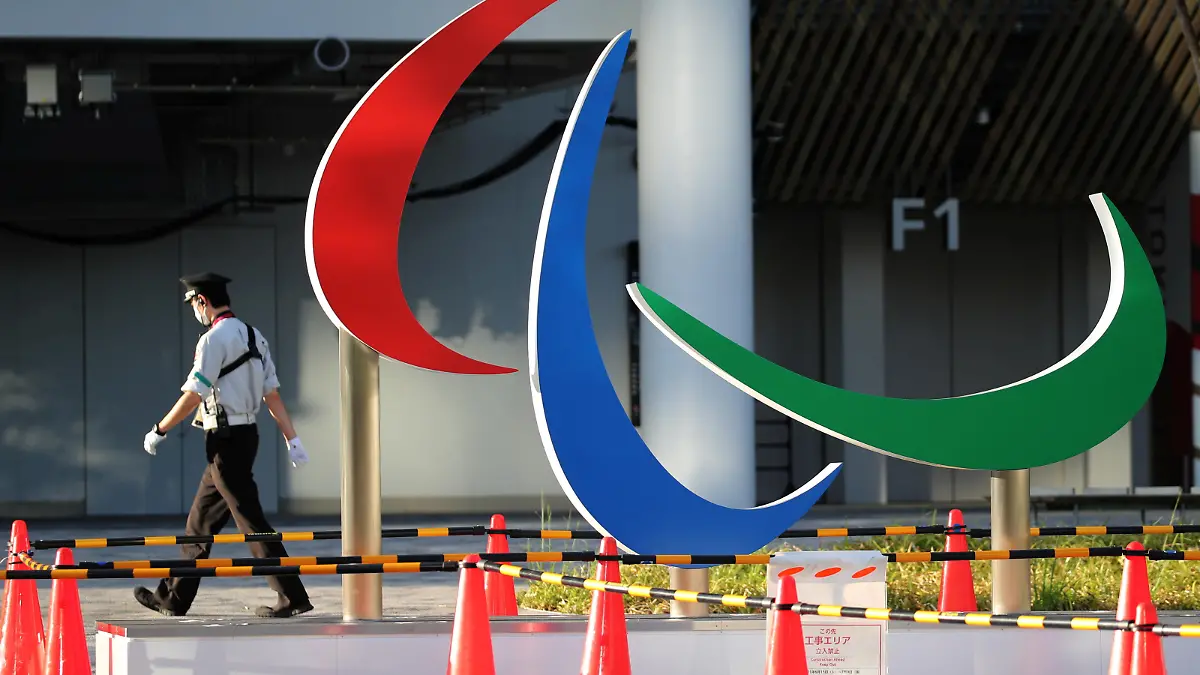 A security guard wearing a protective mask, amid the coronavirus disease (COVID-19) outbreak, walks past the symbol of the Paralympic Games under installation at the National Stadium, the main venue of the Tokyo 2020 Olympic and Paralympic Games in Tokyo, Japan, August 10, 2021.   REUTERS/Kim Kyung-Hoon