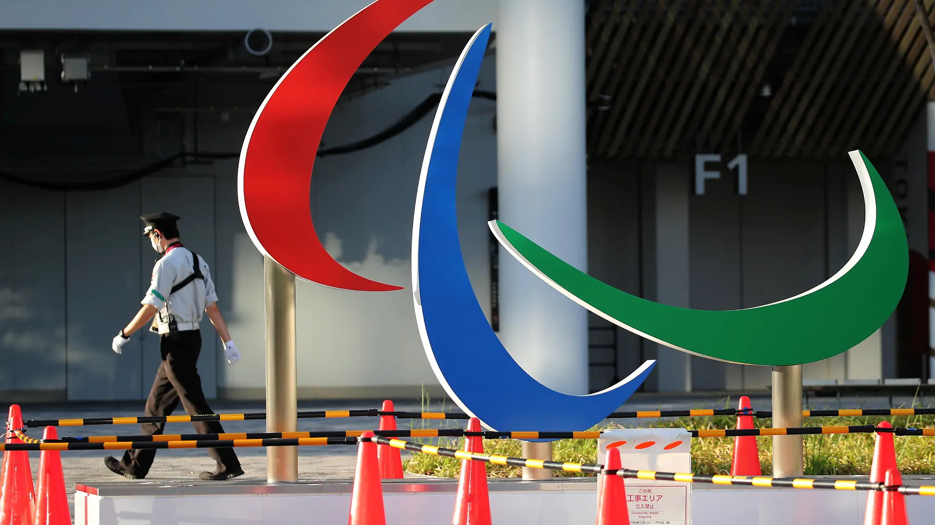 A security guard wearing a protective mask, amid the coronavirus disease (COVID-19) outbreak, walks past the symbol of the Paralympic Games under installation at the National Stadium, the main venue of the Tokyo 2020 Olympic and Paralympic Games in Tokyo, Japan, August 10, 2021. REUTERS/Kim Kyung-Hoon