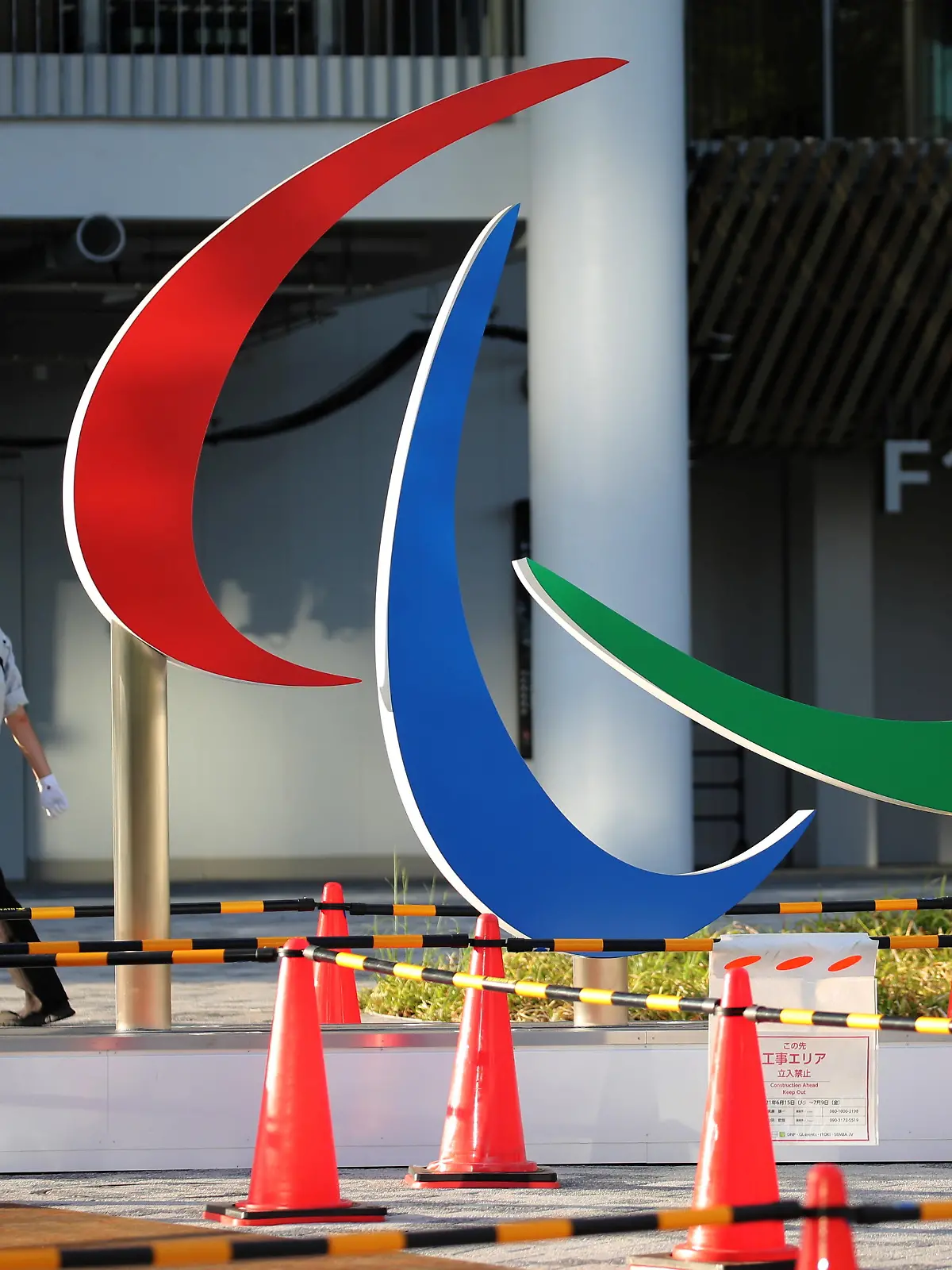 A security guard wearing a protective mask, amid the coronavirus disease (COVID-19) outbreak, walks past the symbol of the Paralympic Games under installation at the National Stadium, the main venue of the Tokyo 2020 Olympic and Paralympic Games in Tokyo, Japan, August 10, 2021.   REUTERS/Kim Kyung-Hoon