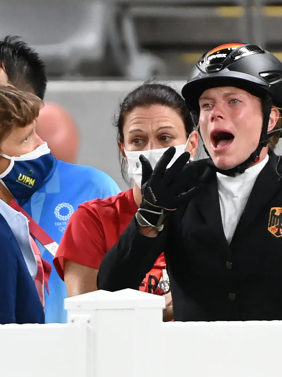 dpatopbilder - 06.08.2021, Japan, Tokio: Moderner Fünfkampf: Olympia, Einzel, Frauen, Springreiten im Tokyo Stadium. Annika Schleu (r) aus Deutschland reagiert. dahinter in der Mitte ist Bundestrainerin Kim Raisner (M). Ihr Pferd hatte mehrmals den Sprung verweigert. Foto: Marijan Murat/dpa +++ dpa-Bildfunk +++
