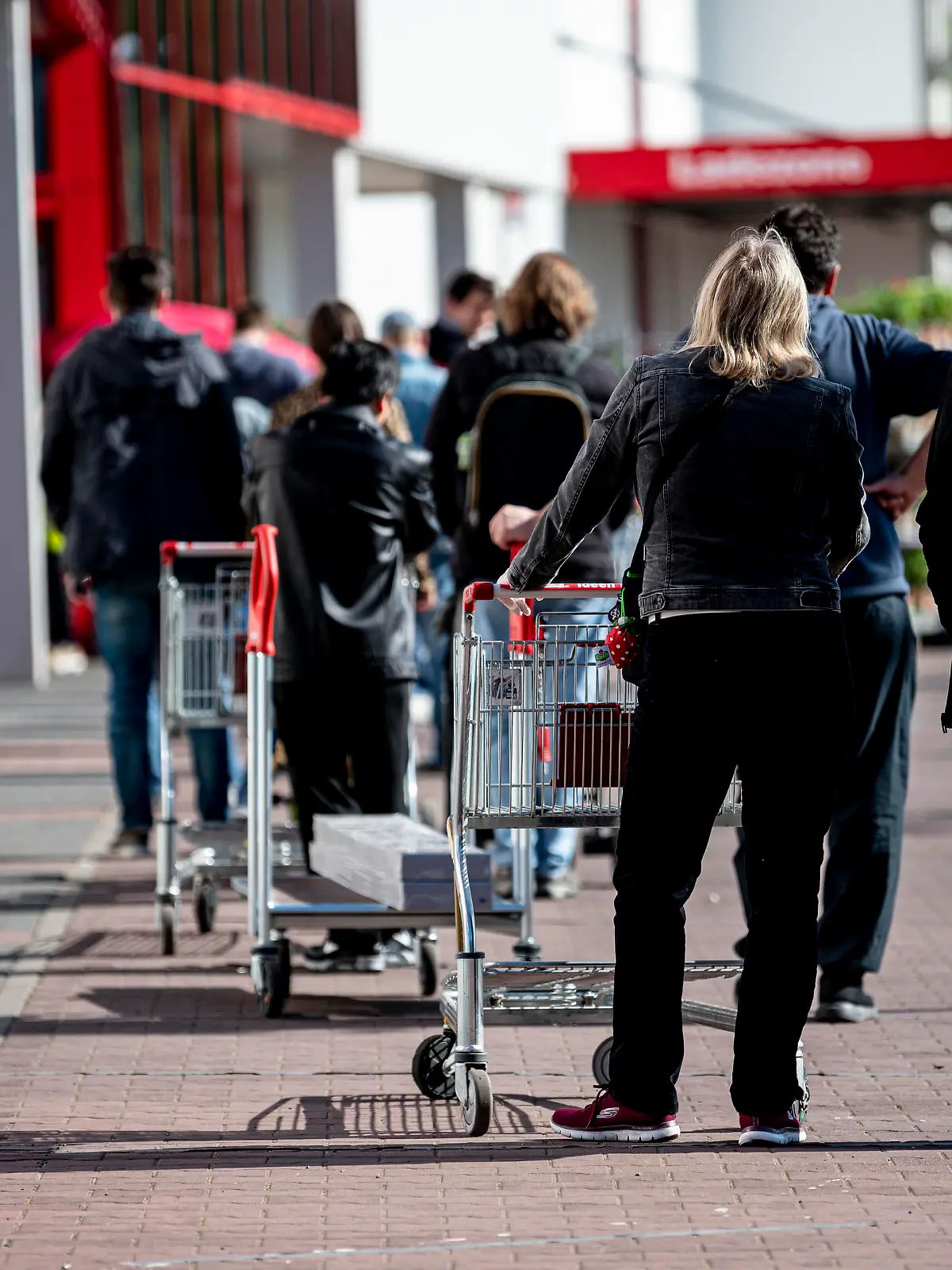 Vor einem Baumarkt in Berlin-Schöneberg bildet sich eine lange Schlange.