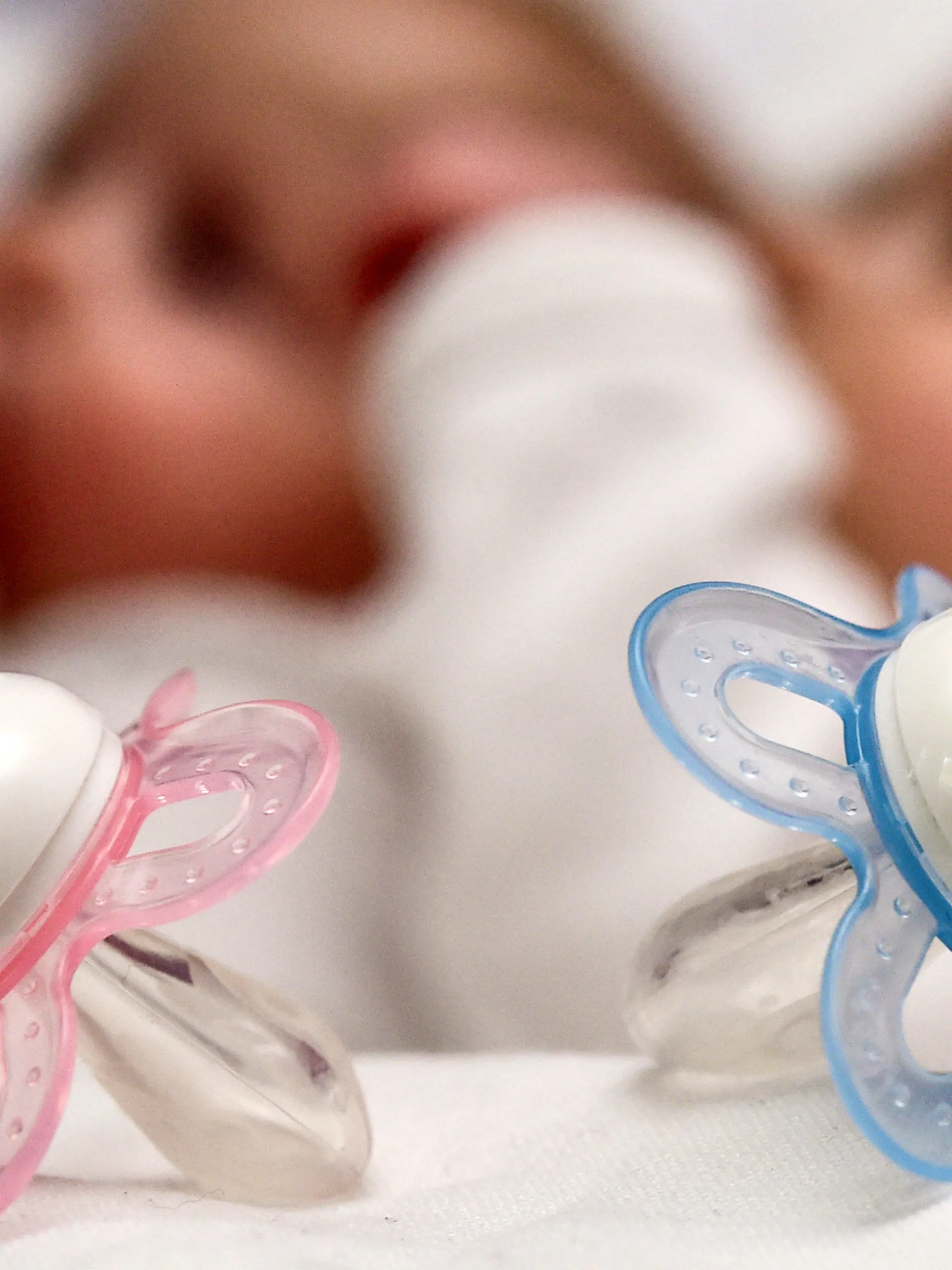 ARCHIV - Ein rosa und ein blauer Schnuller, aufgenommen am 14.04.2015 vor zwei Babys in Frankfurt (Oder) in Brandenburg. Die Geburtenrate in Deutschland ist so hoch wie seit mehr als 30 Jahren nicht mehr. Trotzdem bekommen die Frauen in vielen anderen europäischen Ländern mehr Kinder. (zu dpa Deutschland bei Geburten im EU-Mittelfeld - drei Kinder zu selten vom 15.05.2017) Foto: Patrick Pleul/dpa-Zentralbild/dpa +++(c) dpa - Bildfunk+++