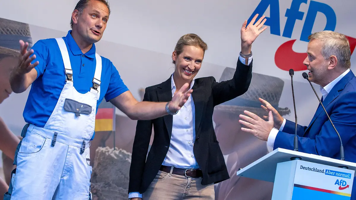 10.08.2021, Mecklenburg-Vorpommern, Schwerin: Alice Weidel und Tino Chrupalla (l), die AfD-Spitzenkandidaten für die Bundestagswahl, und Leif-Erik Holm (r), Bundestagsabgeordneter und Spitzenkandidat in Mecklenburg-Vorpommern, stehen zum Auftakt der Wahlkampftour der AfD auf der Bühne. Die Partei zieht mit dem Slogan «Deutschland. Aber normal.» in den Wahlkampf. Foto: Jens Büttner/dpa-Zentralbild/dpa +++ dpa-Bildfunk +++