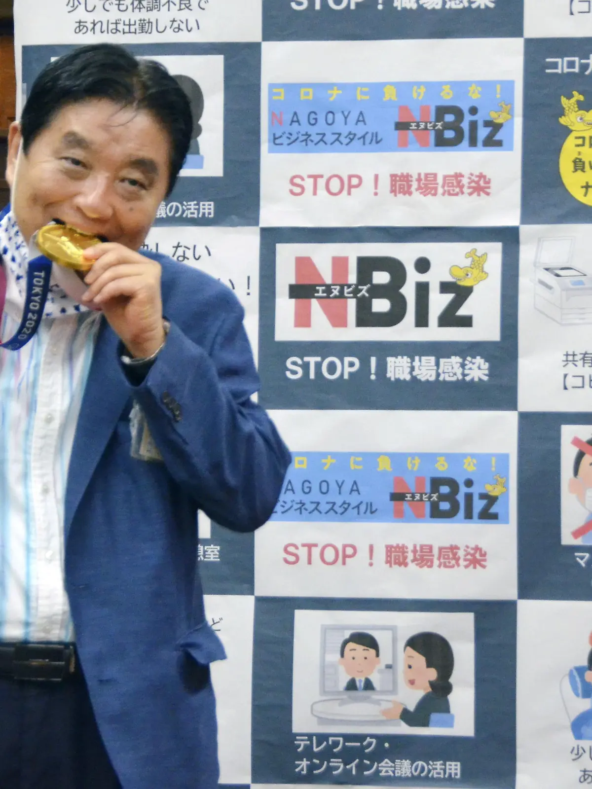 Nagoya city Mayor Takashi Kawamura bites the Tokyo 2020 Olympic Games gold medal of the softball athlete Miu Goto during a ceremony in Nagoya, central Japan, August 4, 2021, in this photo taken by Kyodo. Picture taken August 4, 2021. Mandatory credit Kyodo/via REUTERS   ATTENTION EDITORS - THIS IMAGE WAS PROVIDED BY A THIRD PARTY. MANDATORY CREDIT. JAPAN OUT. NO COMMERCIAL OR EDITORIAL SALES IN JAPAN.