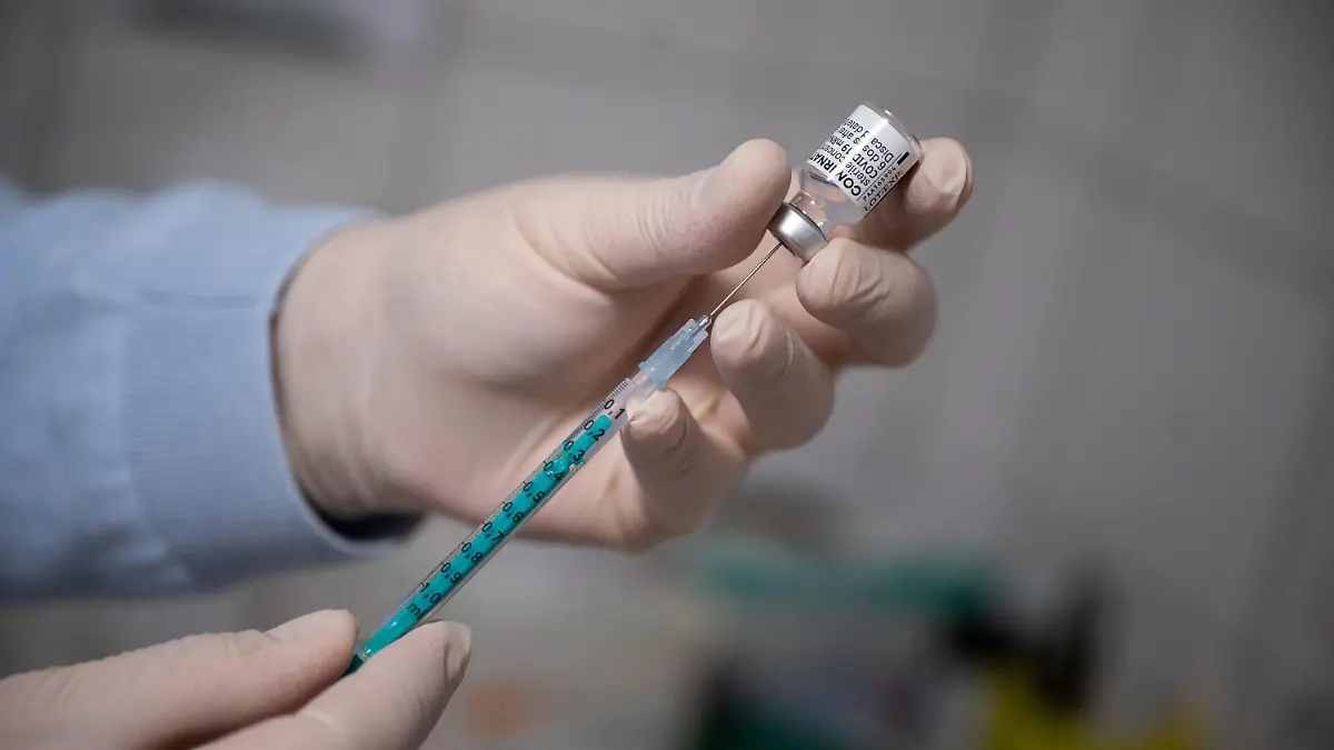 ARCHIV - 06.04.2021, Hessen, Wiesbaden: Ein Arzt zieht in einer Hausarztpraxis eine Spritze mit dem Impfstoff von Pfizer/Biontech auf. (zu dpa: «GEW hofft auf baldige Klärung der Impf-Strategie für Schüler») Foto: Sebastian Gollnow/dpa +++ dpa-Bildfunk +++