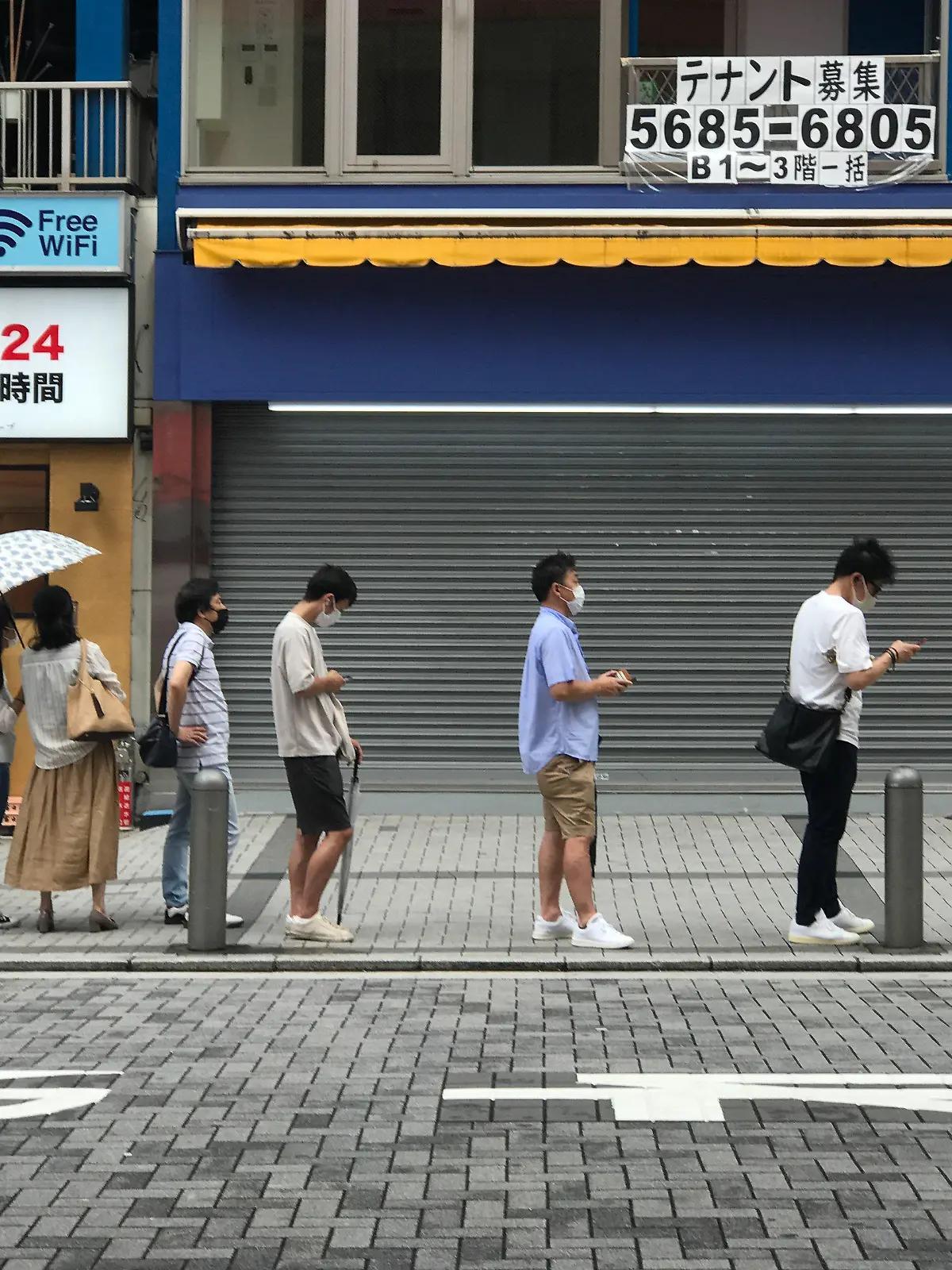 09.08.2021, Tokio: Menschen warten in einer Schlange auf einen PCR-Test. Foto: Marijan Murat/dpa +++ dpa-Bildfunk +++