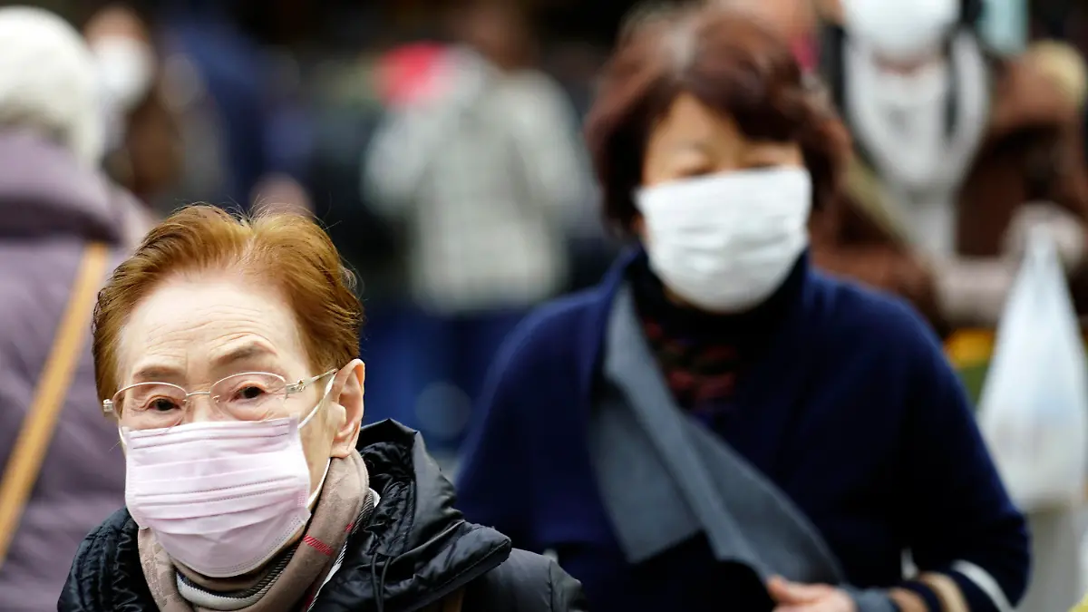 16.01.2020, Japan, Tokio: Fußgänger tragen Schutzmasken, während sie durch ein Einkaufsviertel gehen. Ein Patient in Japan ist positiv auf das in der chinesischen Stadt Wuhan umgehende Corona-Virus getestet worden. Foto: Eugene Hoshiko/AP/dpa +++ dpa-Bildfunk +++