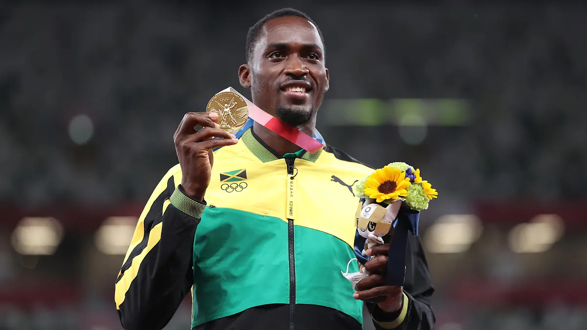 TOKYO, JAPAN - AUGUST 05: Gold medalist Hansle Parchment of Team Jamaica holds up his medal on the podium during the medal ceremony for the Men’s 110m Hurdles on day thirteen of the Tokyo 2020 Olympic Games at Olympic Stadium on August 05, 2021 in Tokyo, Japan. (Photo by Michael Steele/Getty Images)