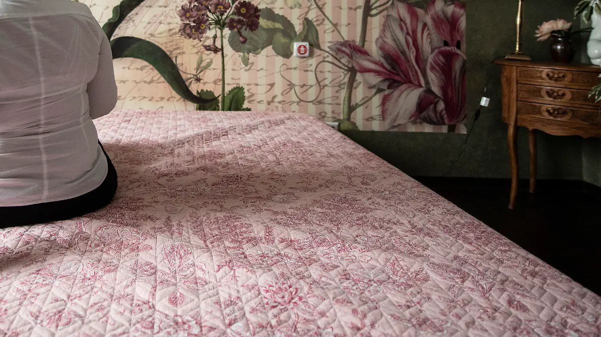 18.01.2021, Rheinland-Pfalz, Speyer: "Lilith" sitzt auf einem Bett im Bordell "Laura's Girls" in Speyer und richtet sich die Haare. Dort wo die Prostituierte sonst auf Kunden wartet herrscht im Corona-Lockdown gähnenden Leere. Wann Laufhäuser und Bordelle wieder öfnnen dürfeb steht noch nicht fest. (Zu dpa "Rotlicht-Gewerbe leidet auch unter dem Lockdown" vom 15.02.2021") Foto: Boris Roessler/dpa +++ dpa-Bildfunk +++