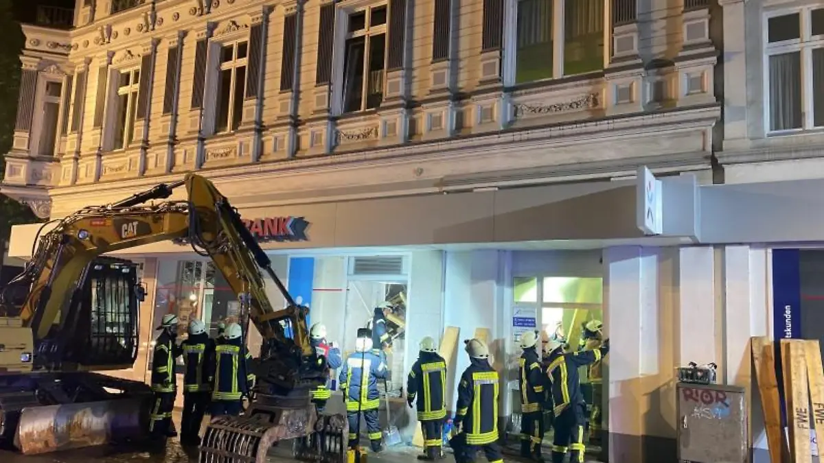 Feuerwehrleute stehen vor einem Haus