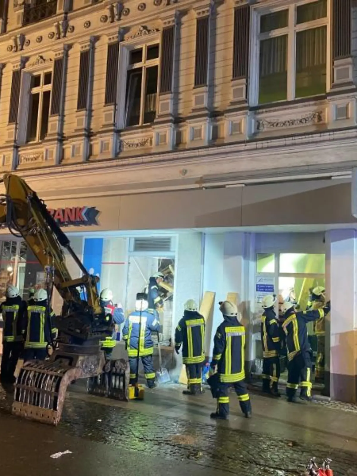 Feuerwehrleute stehen vor einem Haus