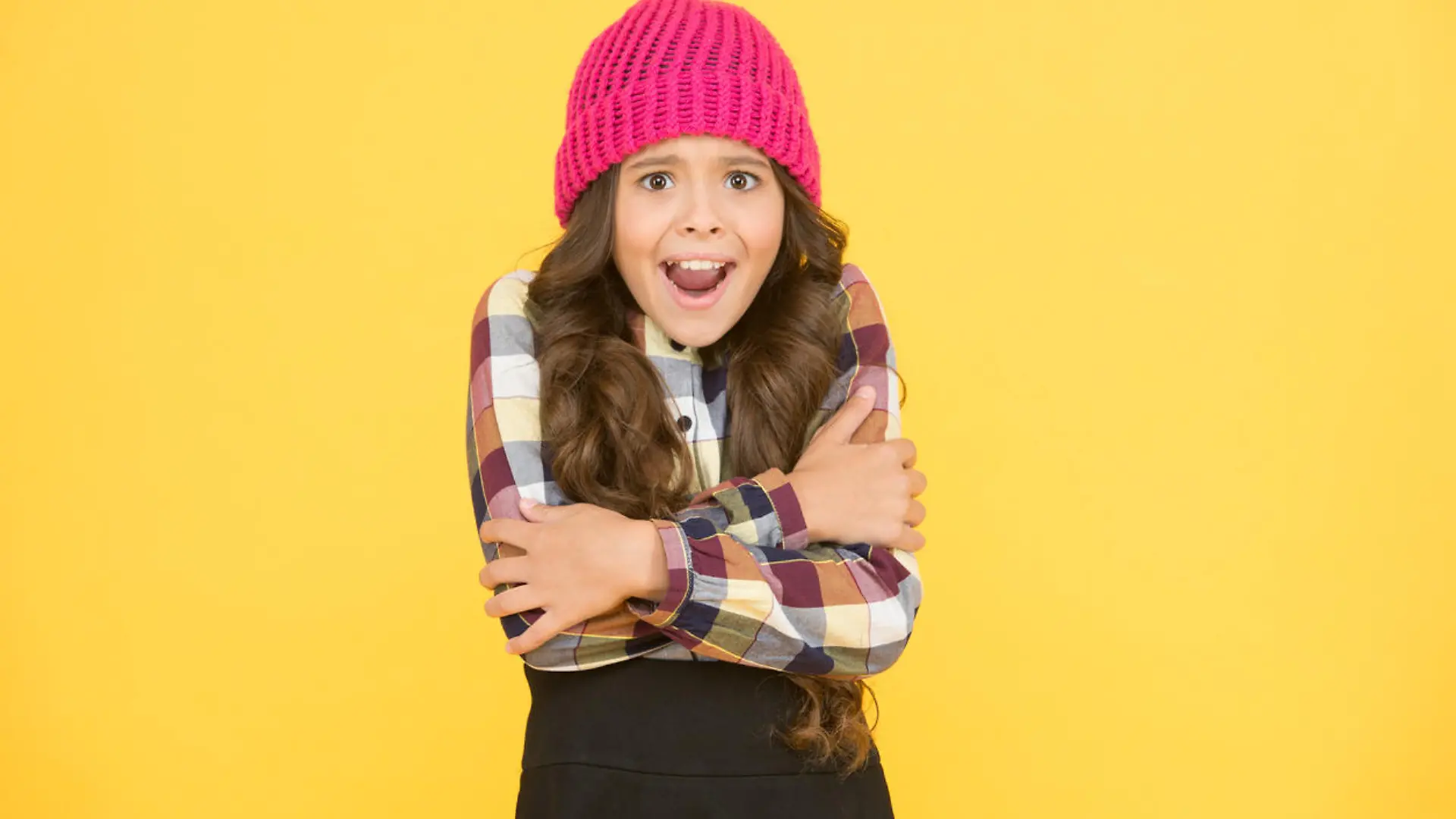 She is cold. Unhappy little child feel cold yellow background. Small girl shiver in cold weather headwear. Crispy autumn or winter season. Chilly and cold. Coldness.