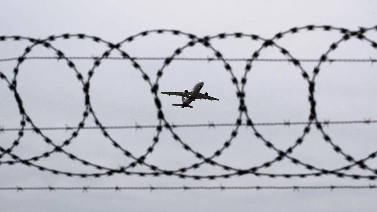 ARCHIV - 06.01.2020, Niedersachsen, Hannover: ILLUSTRATION - Ein Flugzeug startet am Flughafen Hannover - fotografiert durch Stacheldraht am Flughafenzaun. Deutschland schiebt vorerst keine Menschen mehr nach Afghanistan ab. Foto: Julian Stratenschulte/dpa +++ dpa-Bildfunk +++