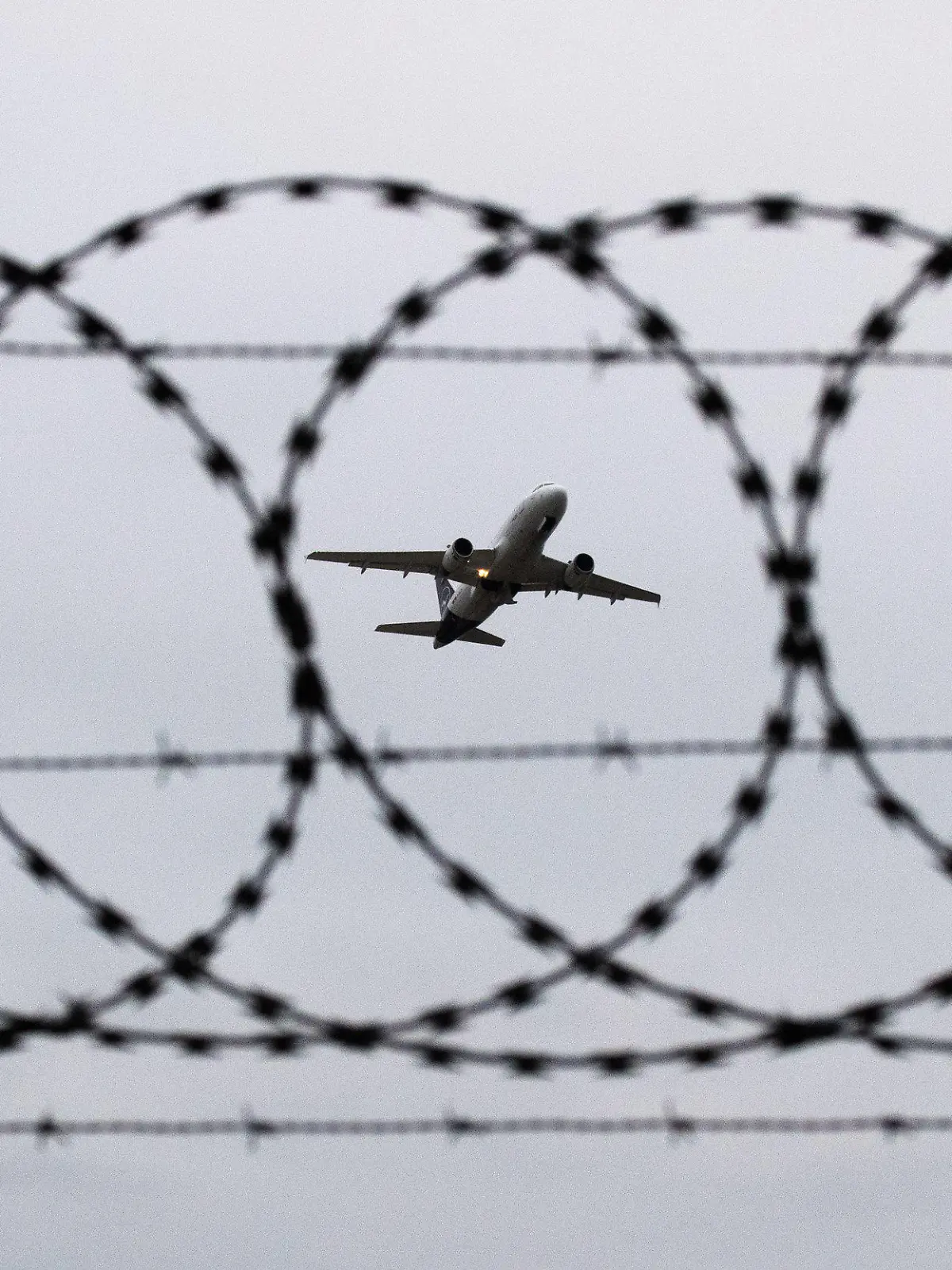 ARCHIV - 06.01.2020, Niedersachsen, Hannover: ILLUSTRATION - Ein Flugzeug startet am Flughafen Hannover - fotografiert durch Stacheldraht am Flughafenzaun. Deutschland schiebt vorerst keine Menschen mehr nach Afghanistan ab. Foto: Julian Stratenschulte/dpa +++ dpa-Bildfunk +++