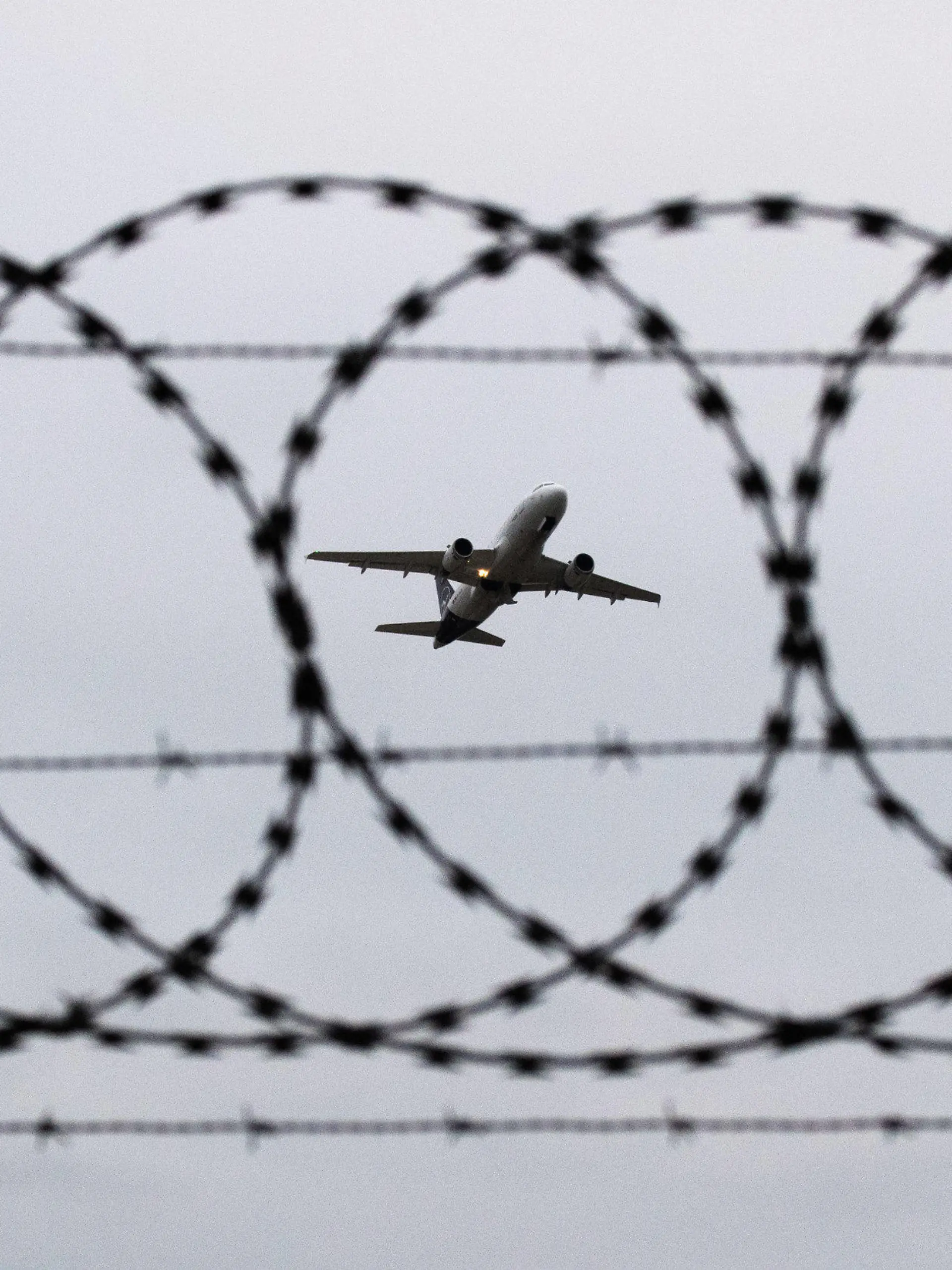 ARCHIV - 06.01.2020, Niedersachsen, Hannover: ILLUSTRATION - Ein Flugzeug startet am Flughafen Hannover - fotografiert durch Stacheldraht am Flughafenzaun. Deutschland schiebt vorerst keine Menschen mehr nach Afghanistan ab. Foto: Julian Stratenschulte/dpa +++ dpa-Bildfunk +++