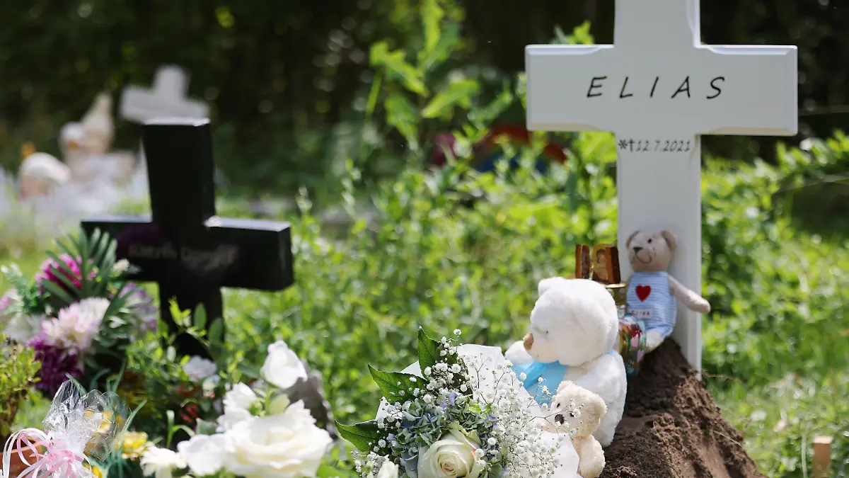 22.07.2021, Nordrhein-Westfalen, Köln: Ein Kreuz mit dem Namen Elias steht an einem Grab auf dem Nordfriedhof. Das Baby, das in der vergangenen Woche tot vor einer Babyklappe in Köln abgelegt wurde, ist beerdigt worden. Der tote Junge war in der vergangenenen Woche im Freien vor der Babyklappe vor einem Frauenhaus entdeckt worden. (Zu dpa/lnw: «Vor Babyklappe gefundener Säugling beerdigt ») Foto: Oliver Berg/dpa +++ dpa-Bildfunk +++