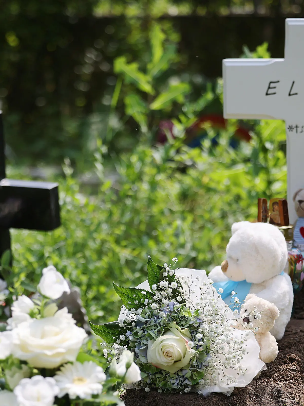 22.07.2021, Nordrhein-Westfalen, Köln: Ein Kreuz mit dem Namen Elias steht an einem Grab auf dem Nordfriedhof. Das Baby, das in der vergangenen Woche tot vor einer Babyklappe in Köln abgelegt wurde, ist beerdigt worden. Der tote Junge war in der vergangenenen Woche im Freien vor der Babyklappe vor einem Frauenhaus entdeckt worden. (Zu dpa/lnw: «Vor Babyklappe gefundener Säugling beerdigt ») Foto: Oliver Berg/dpa +++ dpa-Bildfunk +++