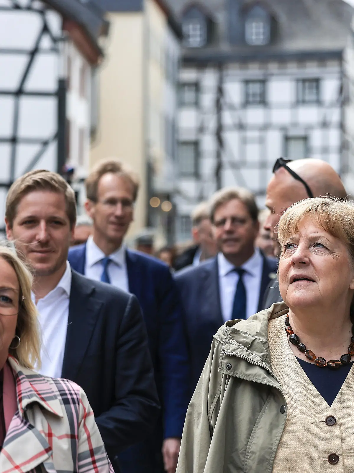 Die ehemalige Bundeskanzlerin Angela Merkel (r, CDU) geht mit der Bürgermeisterin Sabine Preiser-Marian (l, CDU) und Markus Ramers (hinten links, CDU), Landrat Kreis Euskirchen durch Bad Münstereifel. Merkel und Wüst haben vor der Verleihung des Staatspreis an Merkel das von der Flutkatastrophe im Jahr 2021 stark betroffene Bad Münstereifel besucht. Damit löste Merkel ihr Versprechen aus dem Jahr 2021 ein, noch einmal wieder zu kommen.