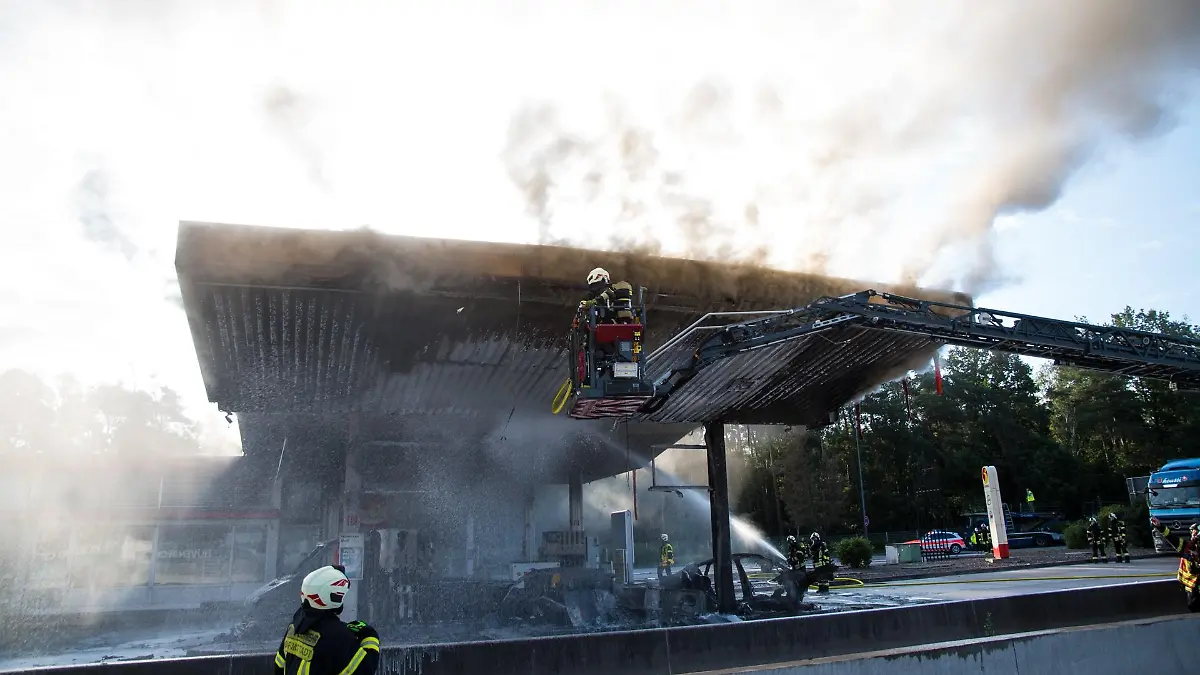 09.08.2021, Hessen, Weiterstadt: Die Feuerwehr löscht einen Brand an der Autobahn-Tankstelle Gräfenhausen Ost. Ein Fahrzeug ist am Morgen an der Raststätte Gräfenhausen Ost auf der Autobahn A5 gegen eine Zapfanlage gefahren und in Brand geraten. Weitere Zapfsäulen hätten Feuer gefangen, berichtete ein Polizeisprecher. Der noch unbekannte Fahrer des Wagens sei tot. Foto: Skander Essadi/5vision.media/dpa +++ dpa-Bildfunk +++