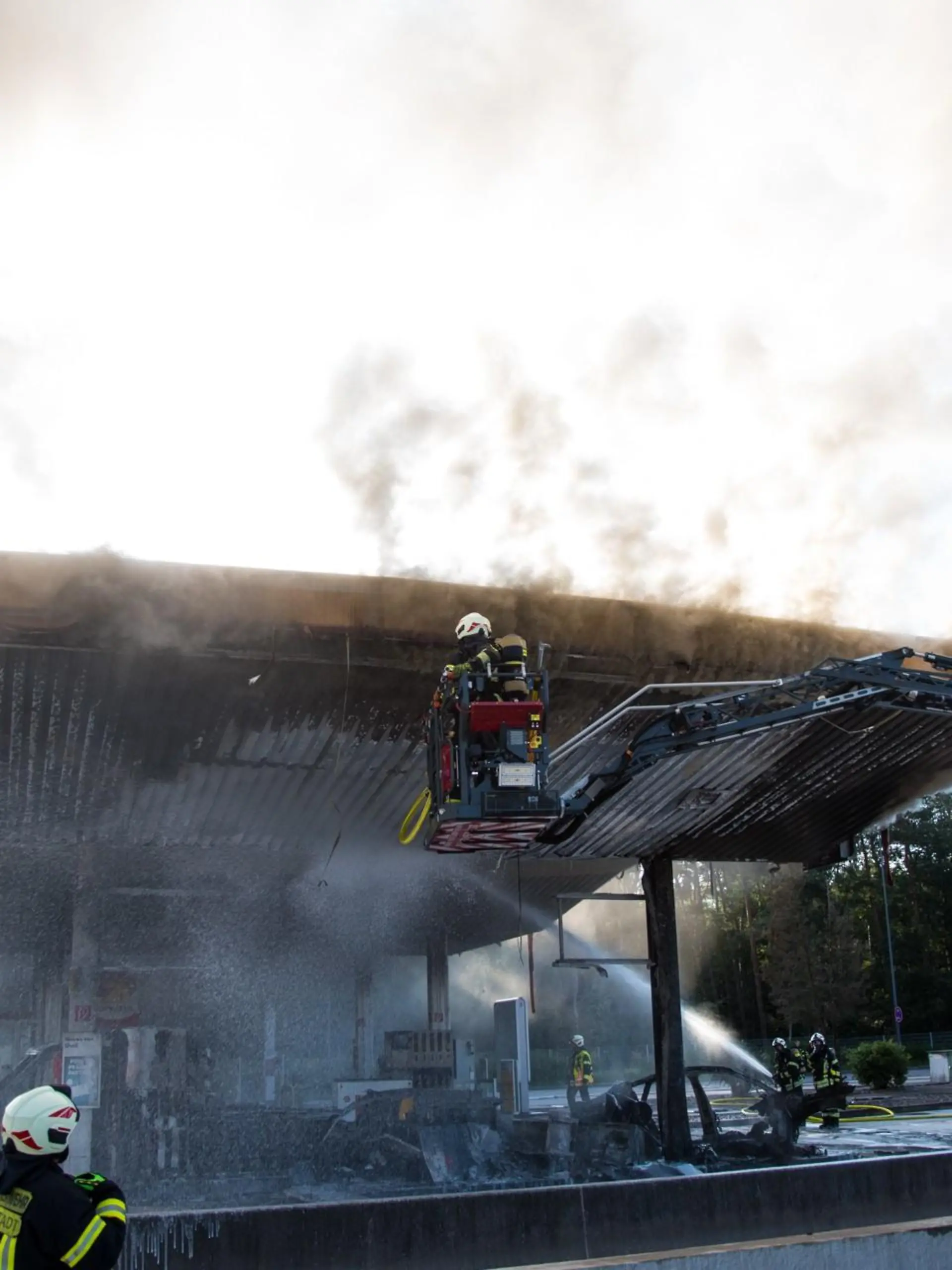 09.08.2021, Hessen, Weiterstadt: Die Feuerwehr löscht einen Brand an der Autobahn-Tankstelle Gräfenhausen Ost. Ein Fahrzeug ist am Morgen an der Raststätte Gräfenhausen Ost auf der Autobahn A5 gegen eine Zapfanlage gefahren und in Brand geraten. Weitere Zapfsäulen hätten Feuer gefangen, berichtete ein Polizeisprecher. Der noch unbekannte Fahrer des Wagens sei tot. Foto: Skander Essadi/5vision.media/dpa +++ dpa-Bildfunk +++