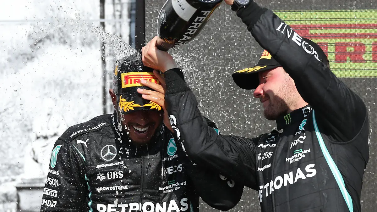 Formula One F1 - British Grand Prix - Silverstone Circuit, Silverstone, Britain - July 18, 2021 Mercedes' Lewis Hamilton celebrates on the podium after winning the race with third place Mercedes' Valtteri Bottas REUTERS/Peter Cziborra
