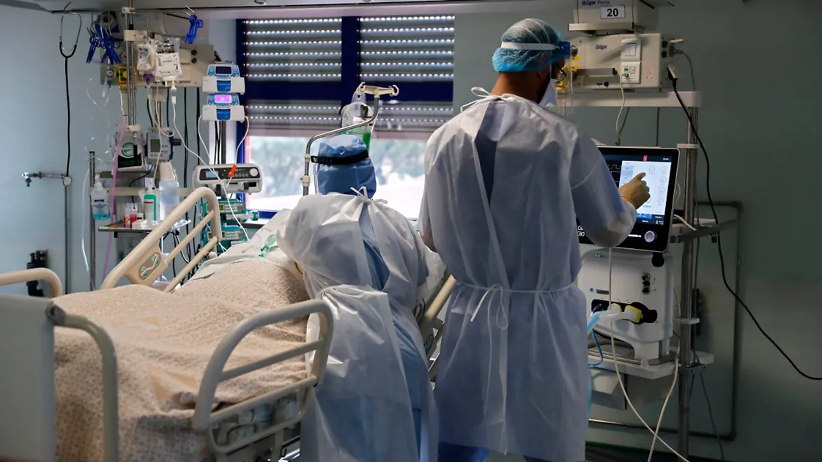 11.02.2021, Portugal, Lissabon: Eine Krankenschwester und ein Arzt kümmern sich um einen Patienten auf der Corona-Intensivstation im Krankenhaus «Curry Cabral Hospital». Nachdem Portugal im vergangenen Monat etwa zwei Wochen lang als das vom Coronavirus am schlimmsten betroffene Land der Welt gemäß der Bevölkerungszahl galt, hat sich die Sorge etwas gelegt. Foto: Armando Franca/AP/dpa +++ dpa-Bildfunk +++