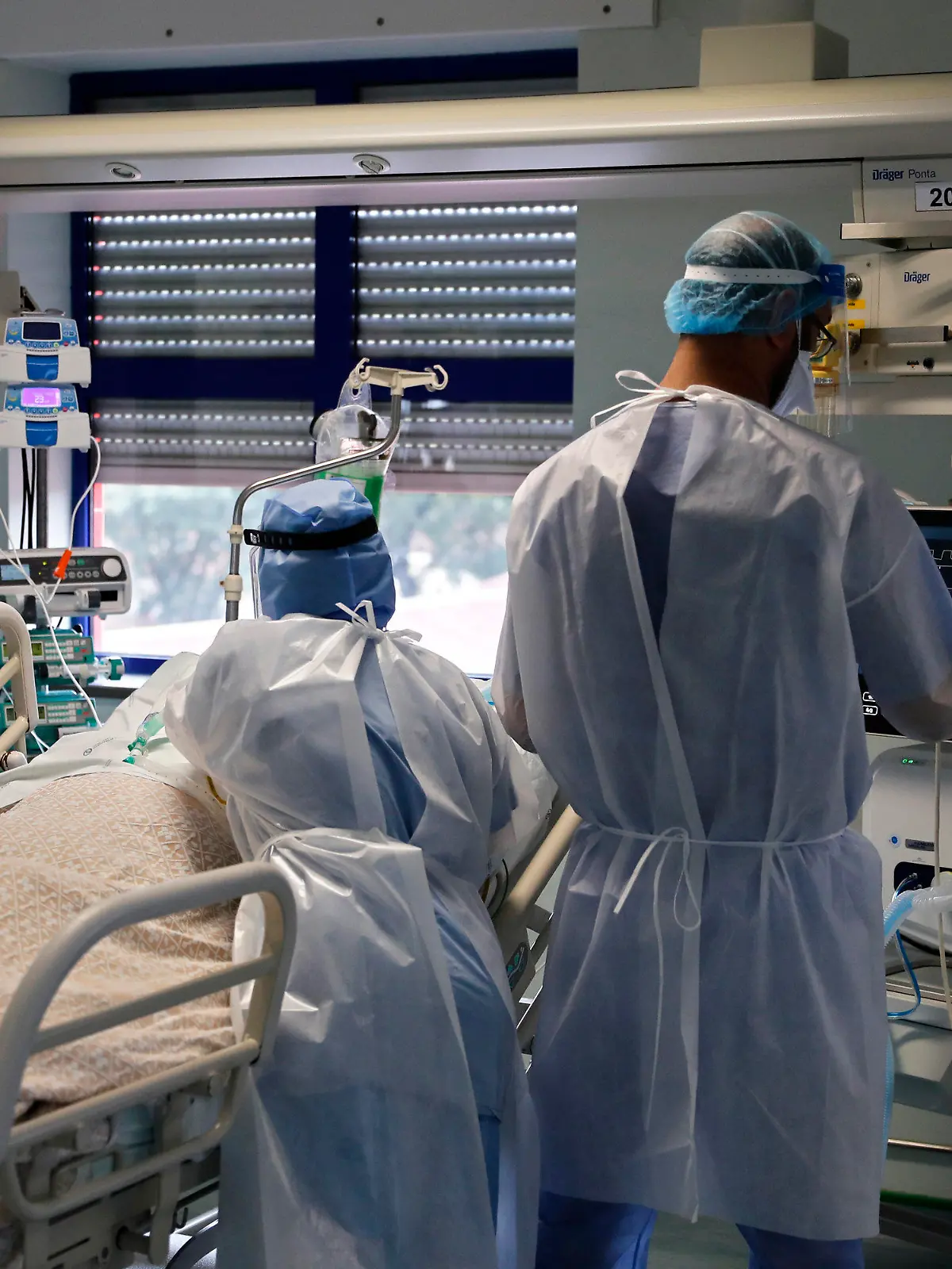 11.02.2021, Portugal, Lissabon: Eine Krankenschwester und ein Arzt kümmern sich um einen Patienten auf der Corona-Intensivstation im Krankenhaus «Curry Cabral Hospital». Nachdem Portugal im vergangenen Monat etwa zwei Wochen lang als das vom Coronavirus am schlimmsten betroffene Land der Welt gemäß der Bevölkerungszahl galt, hat sich die Sorge etwas gelegt. Foto: Armando Franca/AP/dpa +++ dpa-Bildfunk +++