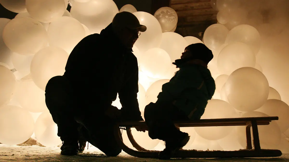 ARCHIV - SYMBOLFOTO - Ein Vater spricht mit seinem auf einem Schlitten sitzenden Sohn in der Zeche Zollverein in Essen bei der Eröffnungsfeier der Kulturhaupstadt "Ruhr.2010" vor großen Ballons (Archivfoto vom 09.01.2010). Das Bundesverfassungsgericht hat die Regelung des Sorgerechts für unverheiratete Väter für verfassungswidrig erklärt. Foto: Julian Stratenschulte dpa/lnw +++(c) dpa - Bildfunk+++