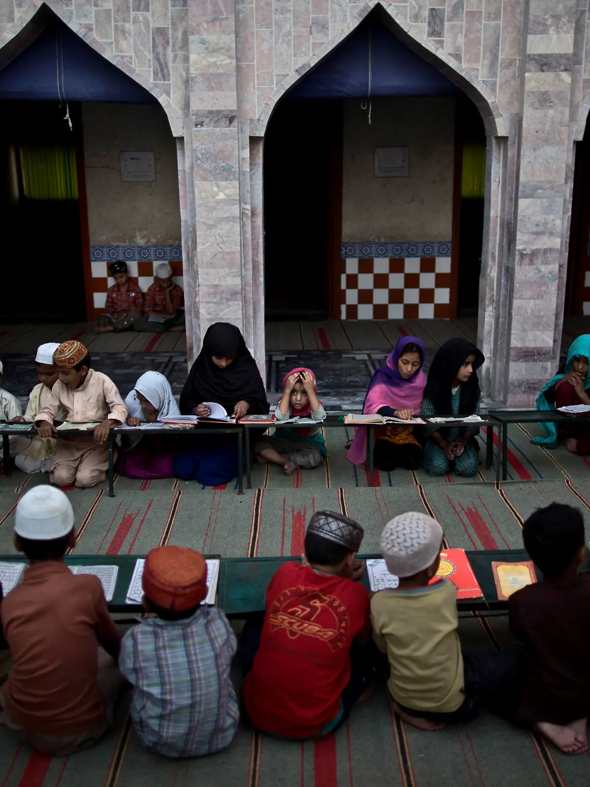 Symbolbild: Islamische Kinder in Pakistan besuchen eine Madrasa (eine religiöse Schule) in Islamabad. (AP Photo/Muhammed Muheisen)