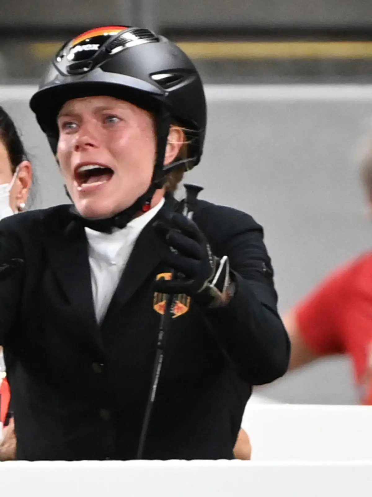 06.08.2021, Japan, Tokio: Moderner Fünfkampf: Olympia, Einzel, Frauen, Springreiten im Tokyo Stadium. Annika Schleu (M) aus Deutschland reagiert, dahinter links ist Bundestrainerin Kim Raisner. Ihr Pferd hatte mehrmals den Sprung verweigert. (zu dpa: «Fünfkampf-Trainerin Raisner von Olympia in Tokio ausgeschlossen») Foto: Marijan Murat/dpa +++ dpa-Bildfunk +++