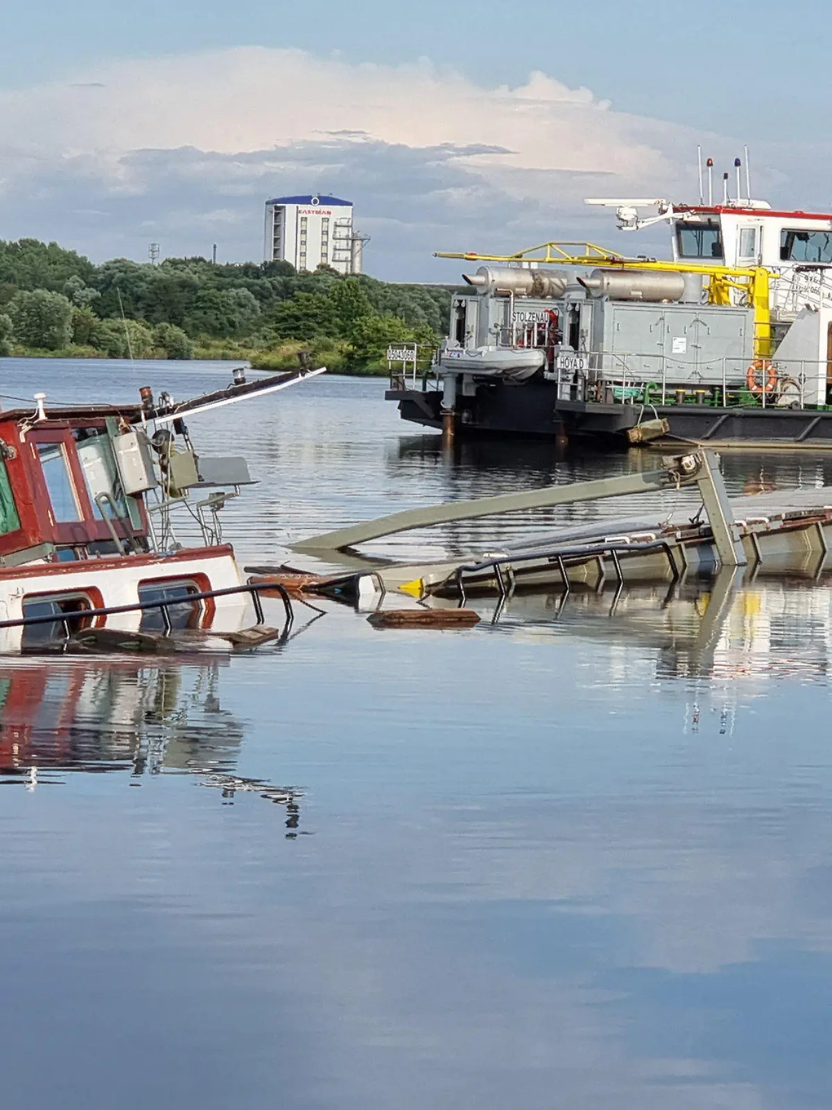 08.08.2021, Niedersachsen, Balge: Nach einer Kollision auf der Weser bei Balge im Landkreis Nienburg geht ein mit mehreren Tonnen Mais beladenes Schiff unter. Es sei aus bislang ungeklärten Umständen mit einem anderen Schiff zusammengestoßen, sagte ein Sprecher der Wasserschutzpolizei. Verletzt wurde nach ersten Erkenntnissen niemand. Da durch den Unfall Betriebsstoffe aus dem Wrack austraten, wurden Ölsperren in dem Bereich ausgelegt. Auch das zweite Schiff wurde beschädigt. Foto: J. Fernando Martinez Lopez/TNN/dpa - ACHTUNG: Name des Schiffes gepixelt +++ dpa-Bildfunk +++