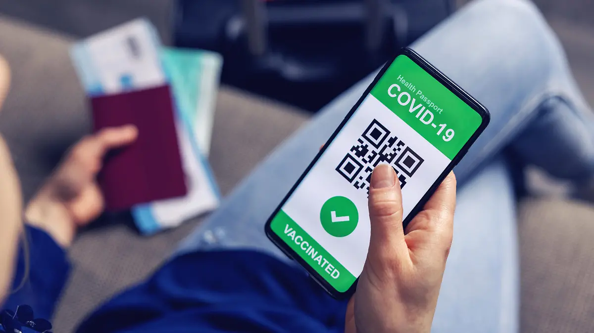 Urlauber mit Impfnachweis und Reisepass am Flughafen