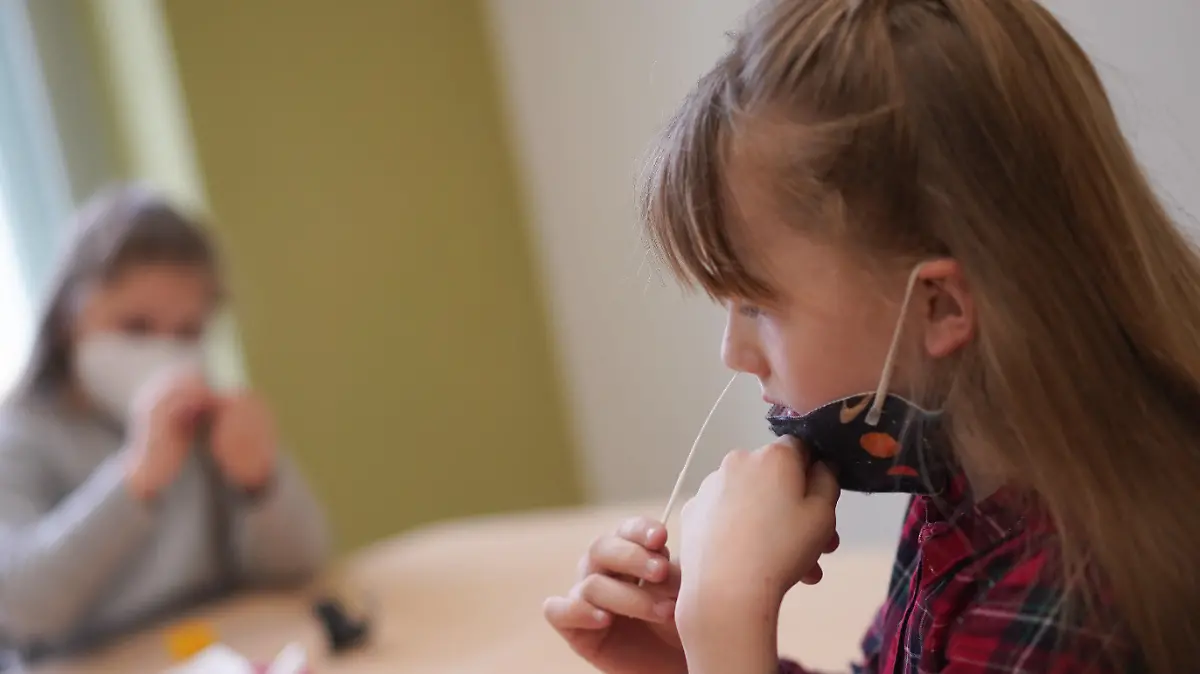 dpatopbilder - 19.04.2021, Berlin: Die Schülerinnen Zeynep (l) und Neele von der Fritz-Karsen-Gemeinschaftsschule führen vor Unterrichtsbeginn einen Corona-Selbsttest durch. Die Berliner Kinder müssen ab heute in den Schulen auf das Coronavirus getestet werden. Foto: Jörg Carstensen/dpa +++ dpa-Bildfunk +++