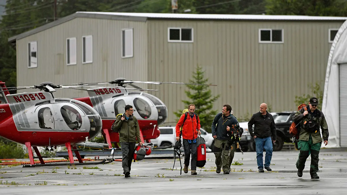 05.08.2021, USA, Ketchikan: Mitarbeiter des Ketchikan Volunteer Rescue Squad landen bei Temsco Helicopters Inc. und steigen aus einem Hughes 369D-Hubschrauber aus. (zu dpa «Kreuzfahrtpassagiere sterben bei Rundflug: Sechs Tote in Alaska») Foto: Dustin Safranek/Ketchikan Daily News/AP/dpa +++ dpa-Bildfunk +++