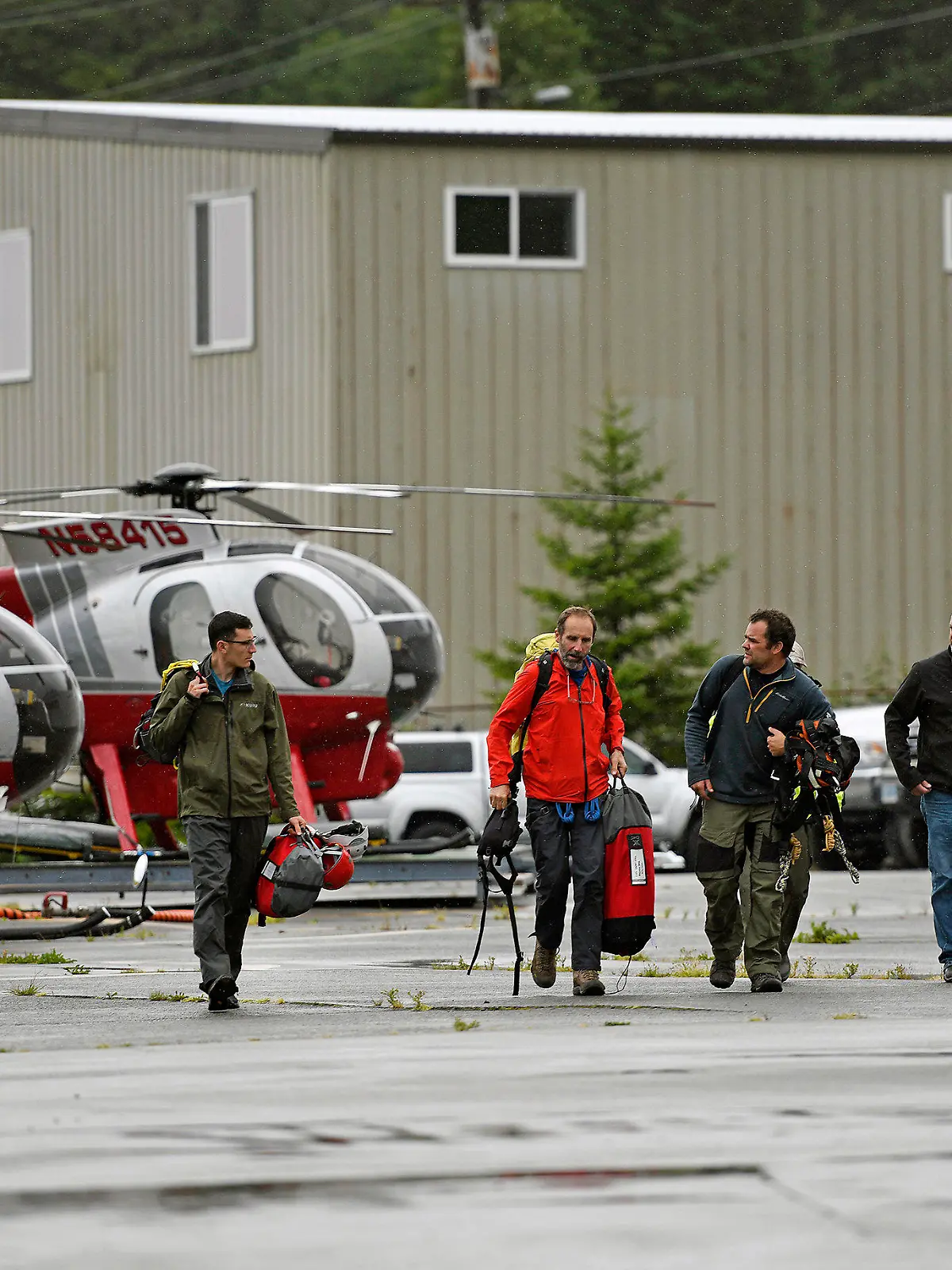 05.08.2021, USA, Ketchikan: Mitarbeiter des Ketchikan Volunteer Rescue Squad landen bei Temsco Helicopters Inc. und steigen aus einem Hughes 369D-Hubschrauber aus. (zu dpa «Kreuzfahrtpassagiere sterben bei Rundflug: Sechs Tote in Alaska») Foto: Dustin Safranek/Ketchikan Daily News/AP/dpa +++ dpa-Bildfunk +++