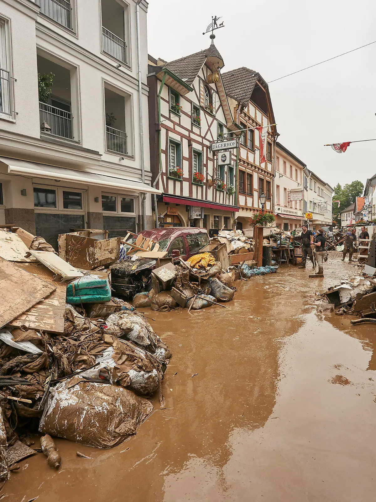 ARCHIV - 17.07.2021, Rheinland-Pfalz, Bad Neuenahr-Ahrweiler: Anwohner und Ladeninhaber versuchen, nach der verheerenden Hochwassernacht ihre Häuser vom Schlamm zu befreien und unbrauchbares Mobiliar nach draußen zu bringen. (zu dpa "FAZ»: Trotz präziser Warnung erst spät Katastrophenfall ausgerufen") Foto: Thomas Frey/dpa +++ dpa-Bildfunk +++