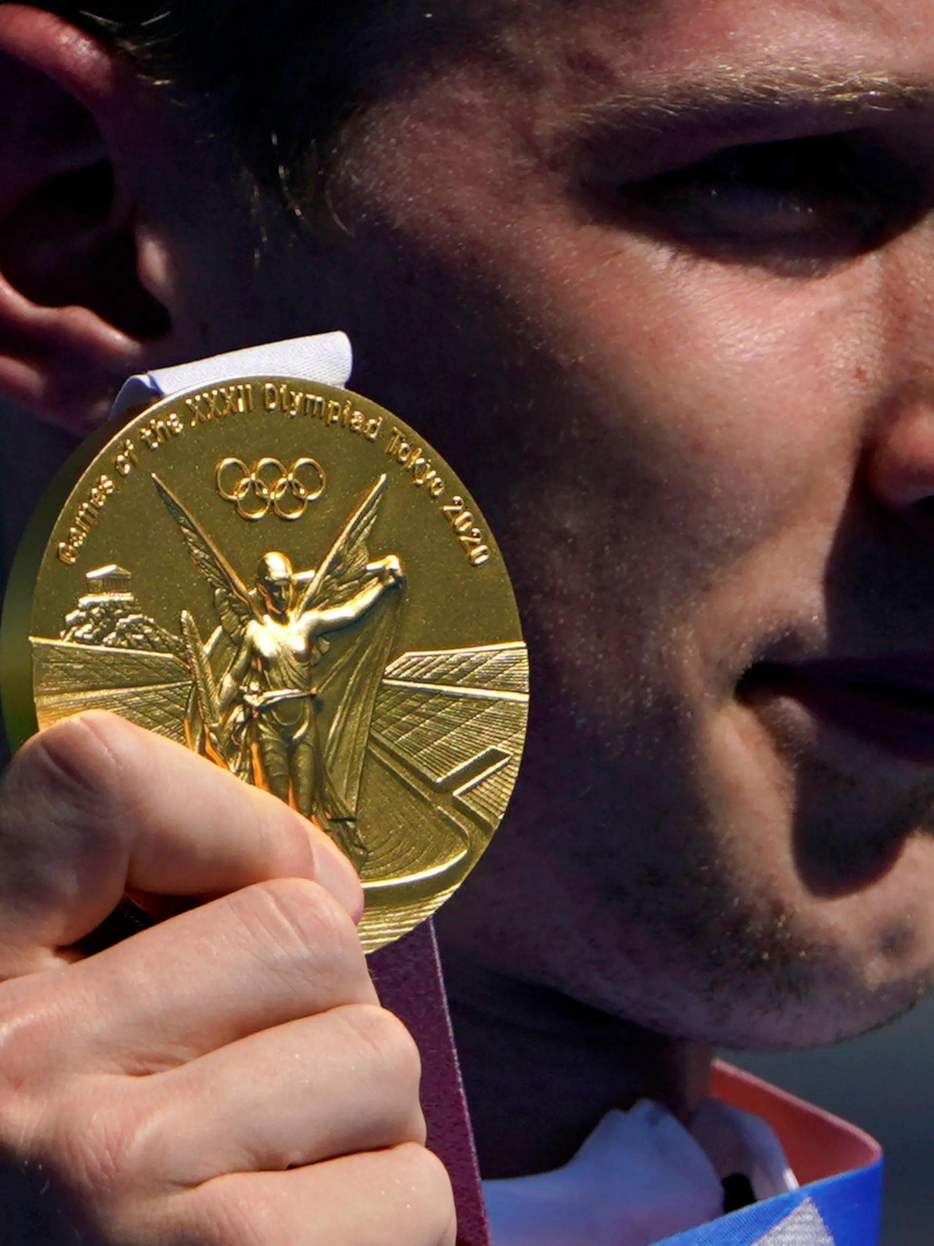 Florian Wellbrock, of Germany, holds up his gold medal during a victory ceremony for the men's marathon swimming event at the 2020 Summer Olympics, Thursday, Aug. 5, 2021, in Tokyo. (AP Photo/David Goldman)