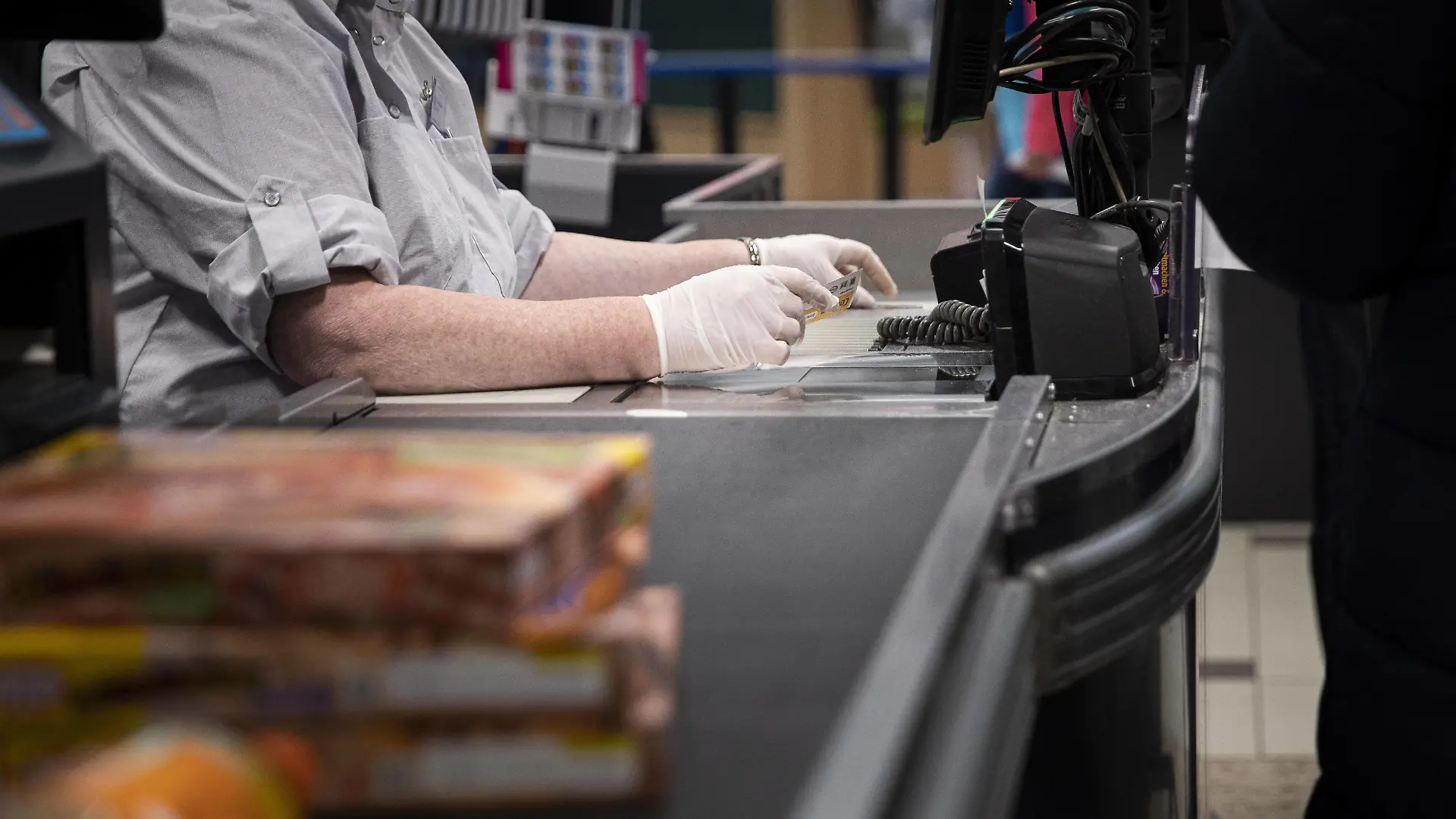 Eine Kassiererin nimmt Geld mit Handschuhen entgegen, aufgenommen in einem Supermarkt in Goerlitz, 24.03.2020. Sachsenweit gibt es Ausgangsbeschraenkungen aufgrund der Ausbreitung des Coronaviruses. Goerlitz Deutschland *** A cashier accepts money with gloves, taken in a supermarket in Goerlitz, 24 03 2020 Throughout Saxony, there are exit restrictions due to the spread of the corona virus Goerlitz Germany Copyright: xFlorianxGaertner/photothek.netx