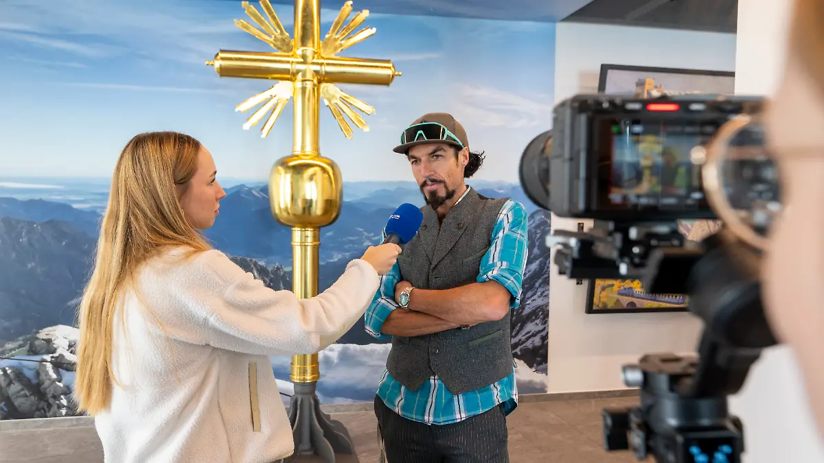 Künstler Bernhard Rieger (r.) vor dem zweiten Gipfelkreuz auf der Zugspitze. Seit Juli können sich Besucher auf dem Kreuz in den Innenräumen der Gipfelstation ganz ohne risikoreiche Kletterei verewigen.