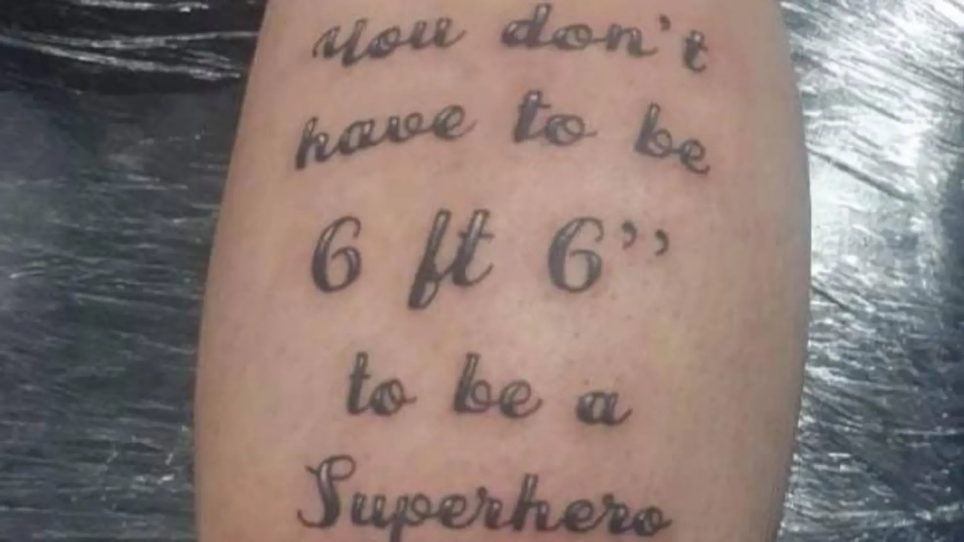 Das Tattoo auf Kevs Wade zeigt Vater und Sohn sowie den Spruch "Du musst keine zwei Meter groß sein, um ein Superheld zu sein".
