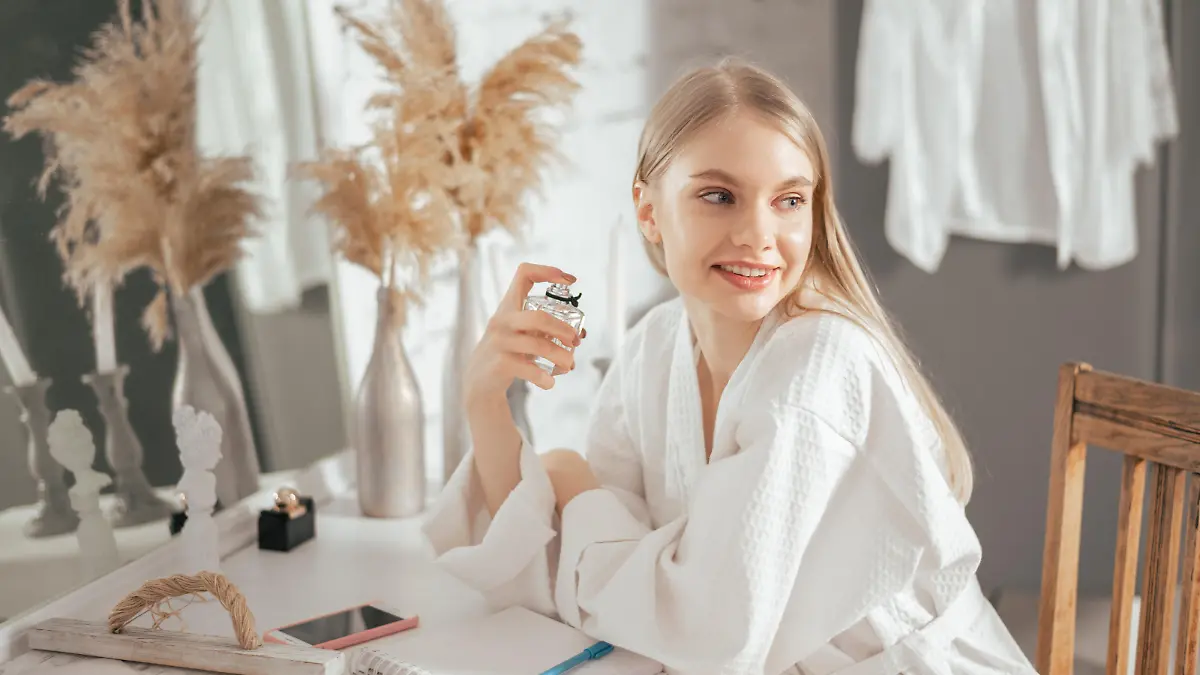 Frau trägt Parfum auf.