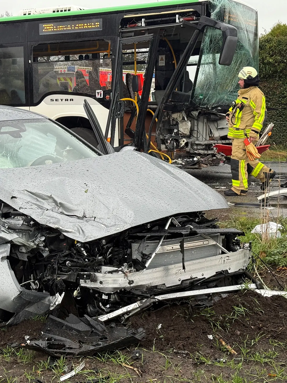 19.11.2025, Nordrhein-Westfalen, Dorsten: Ein Bus und ein Auto stehen nach einem Unfall demoliert an einer Straße. In dem Bus haben nach Angaben der Polizei zahlreiche Kinder gesessen.