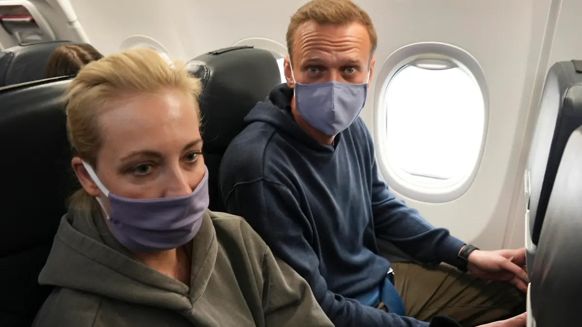 dpatopbilder - 17.01.2021, Schönefeld: Kremlgegner Alexej Nawalny (r) und seine Ehefrau Julia sitzen mit Mund-Nasen-Schutz in einem Flugzeug der Fluggesellschaft "Pobeda", um nach Moskau zu fliegen. Nawalny hielt sich für die Behandlung nach seiner Vergiftung für fast fünf Monate in Deutschland auf. Der 44-Jährige gilt als der prominenteste Gegner des russischen Präsidenten Putin. Nawalny will seinen politischen Kampf gegen Putin fortsetzen. Foto: Mstyslav Chernov/AP/dpa +++ dpa-Bildfunk +++