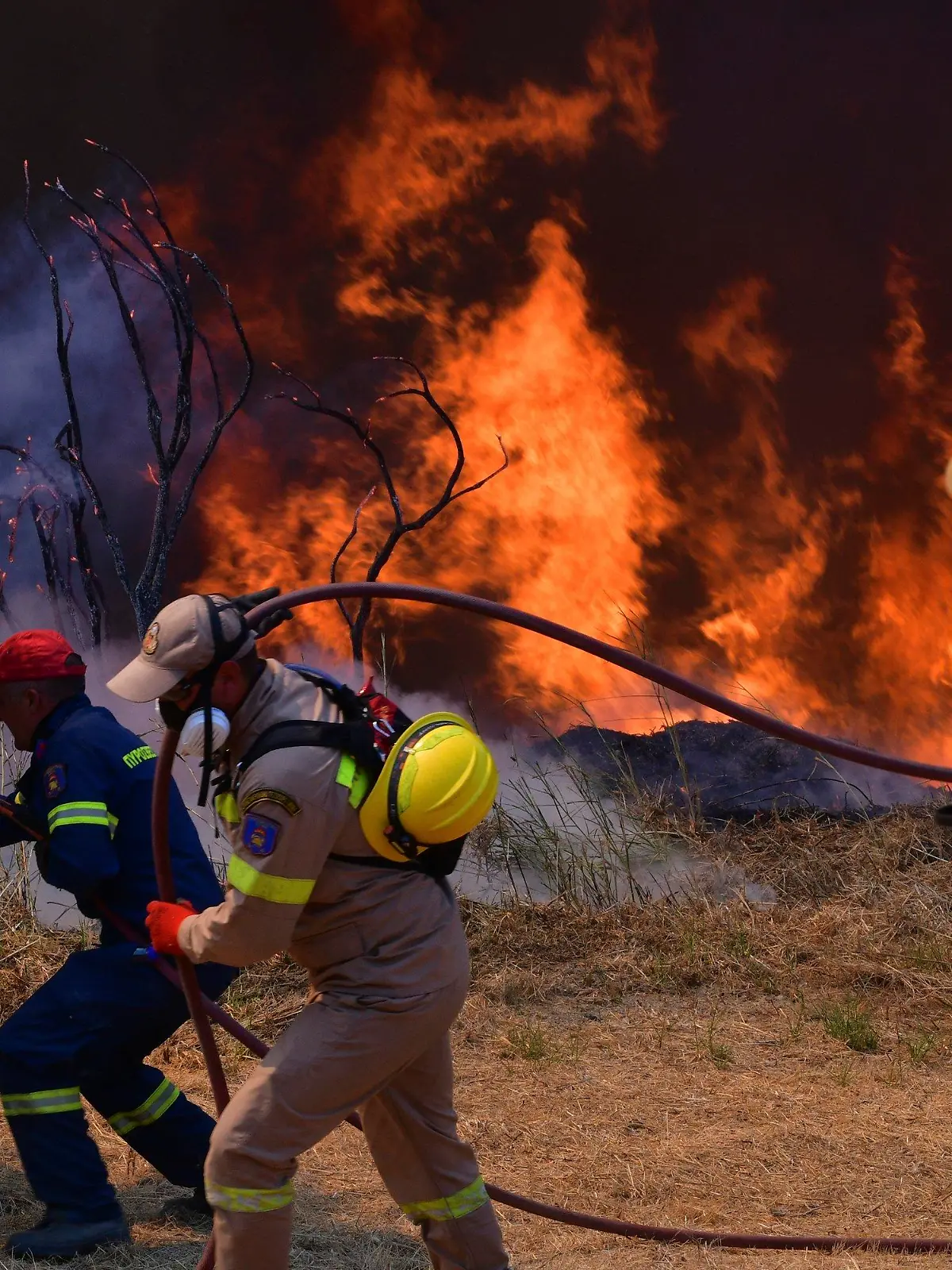 05.08.2021, Griechenland, Olympia: Feuerwehrleute bekämpfen einen Waldbrand in der Nähe der Stadt Olympia. Einsatzkräfte sind nach wie vor im Einsatz und bekämpfen Waldbrände. Das Feuer nördlich von Athen ist erneut voll aufgeflammt. Foto: Giannis Spyrounis/ilialive.gr/AP/dpa +++ dpa-Bildfunk +++
