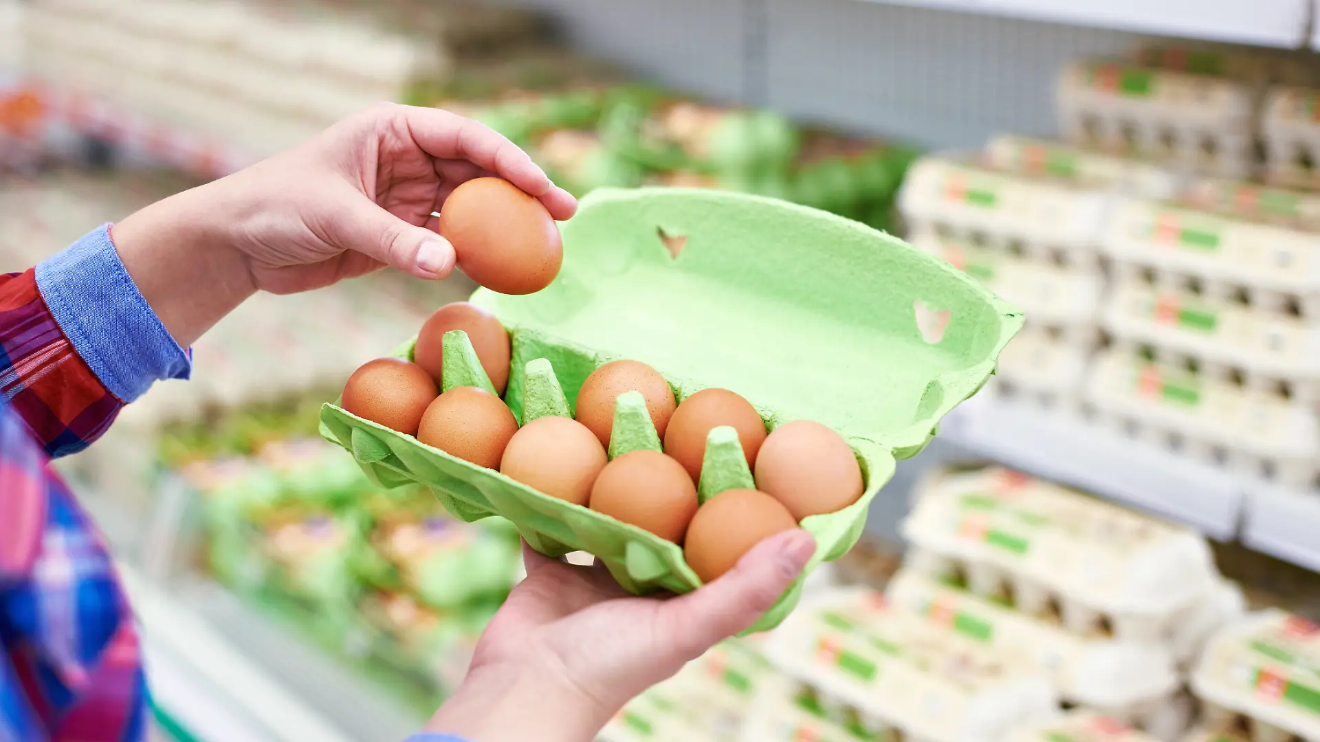 Frau, die Eier im Supermarkt kontrolliert