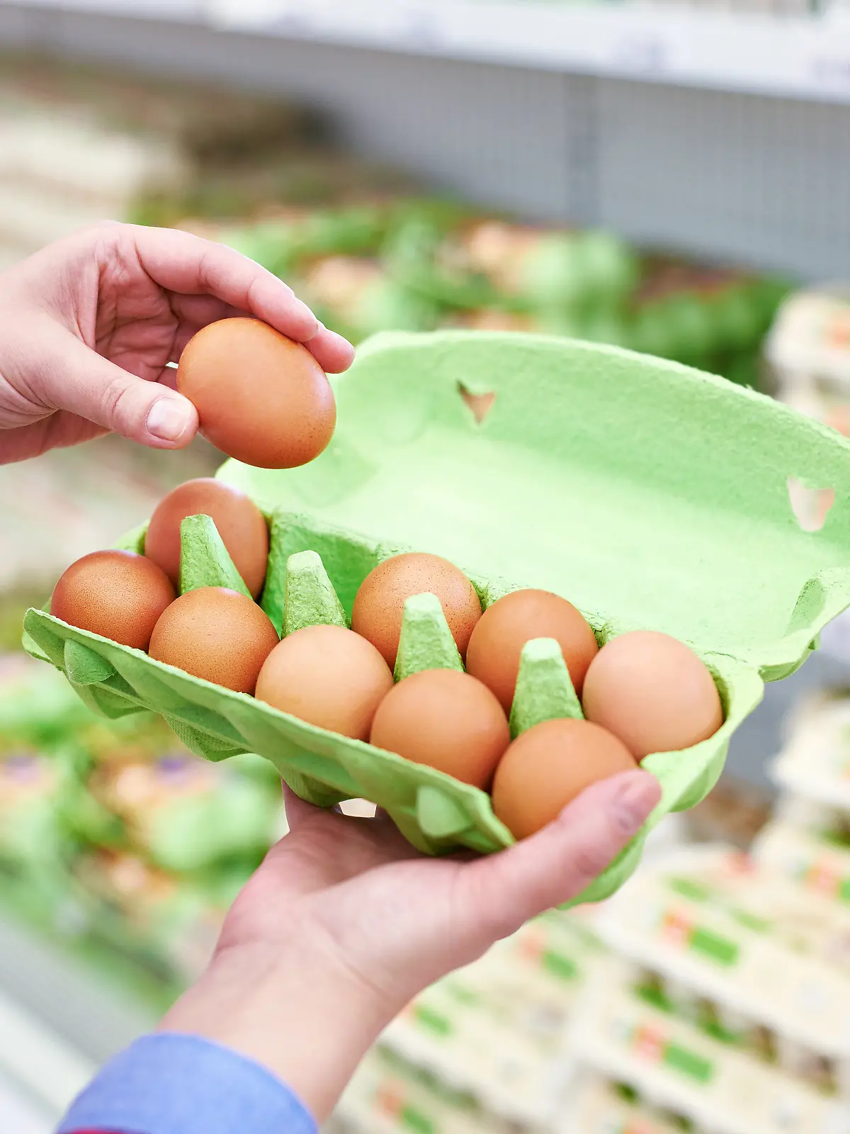 Frau, die Eier im Supermarkt kontrolliert
