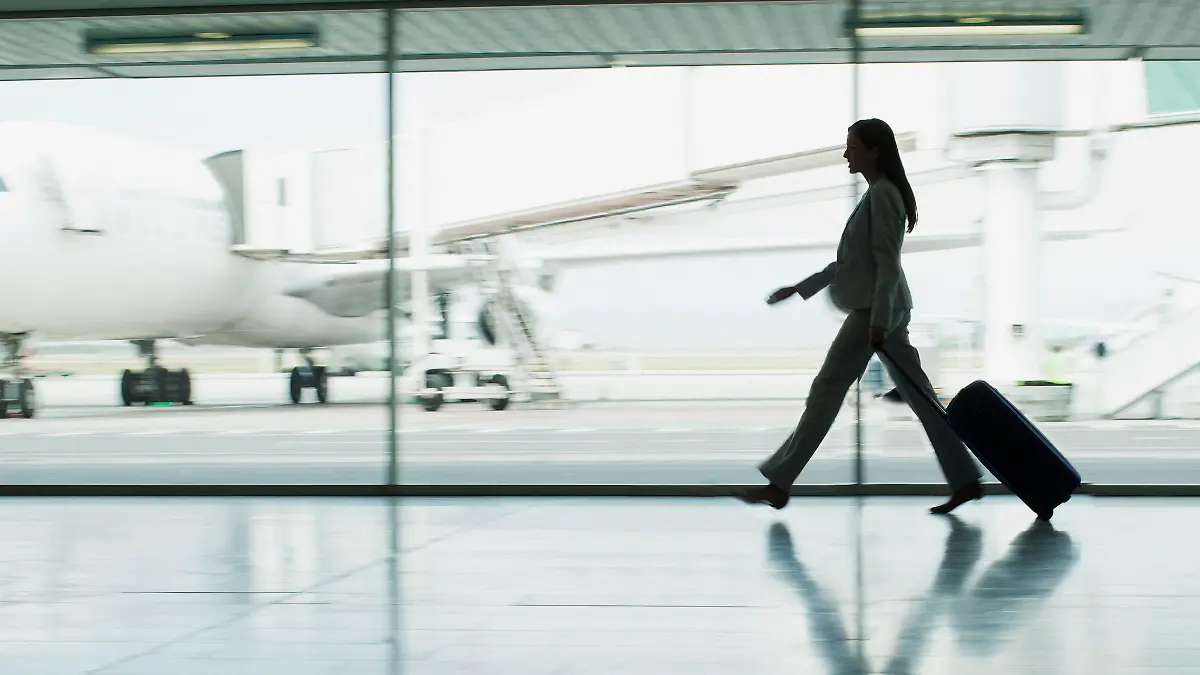 Passagier mit Rollkoffer auf dem Flughafen.