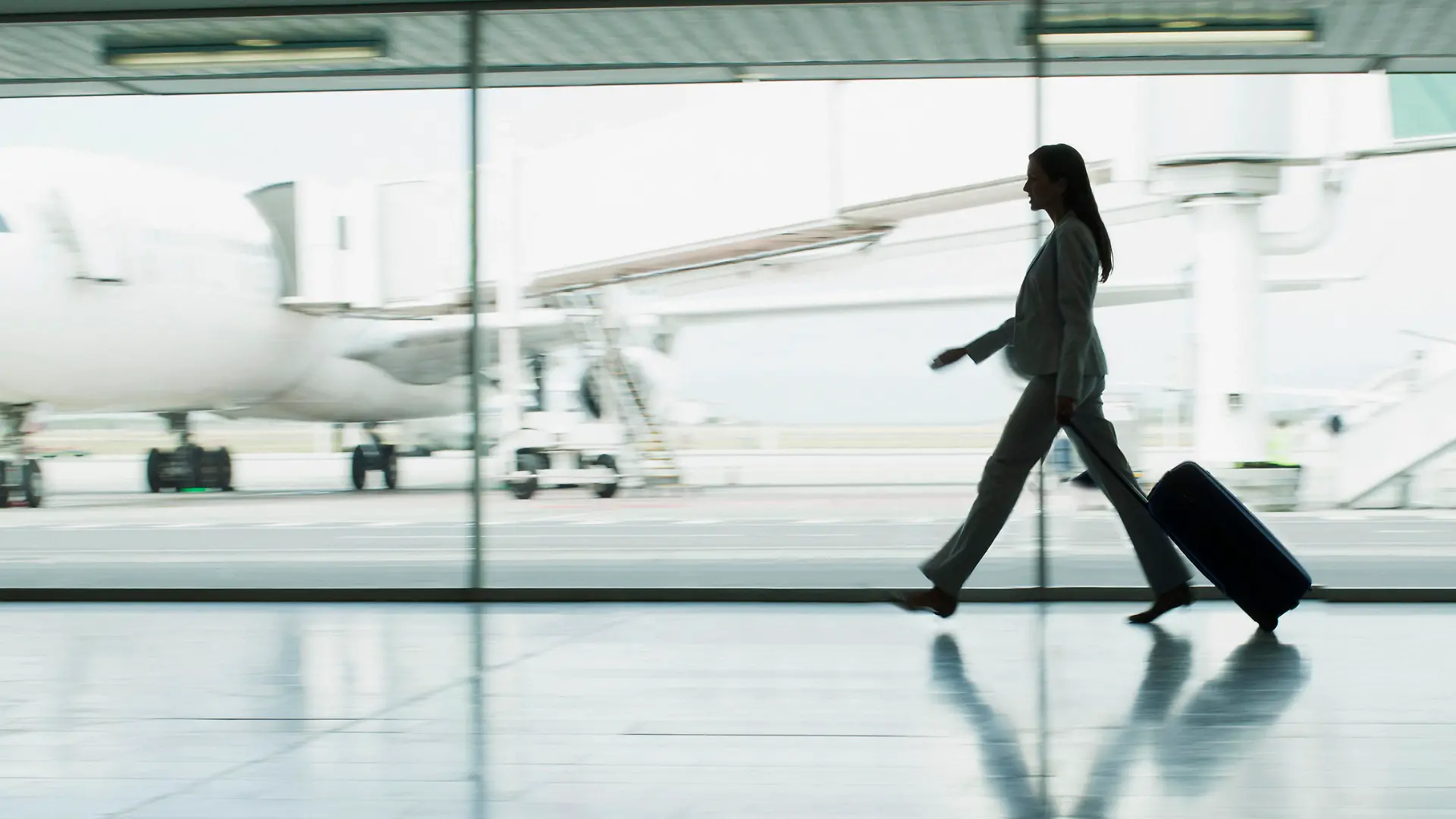 Passagier mit Rollkoffer auf dem Flughafen.