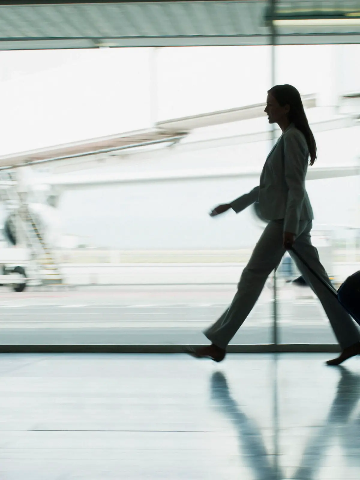 Passagier mit Rollkoffer auf dem Flughafen.